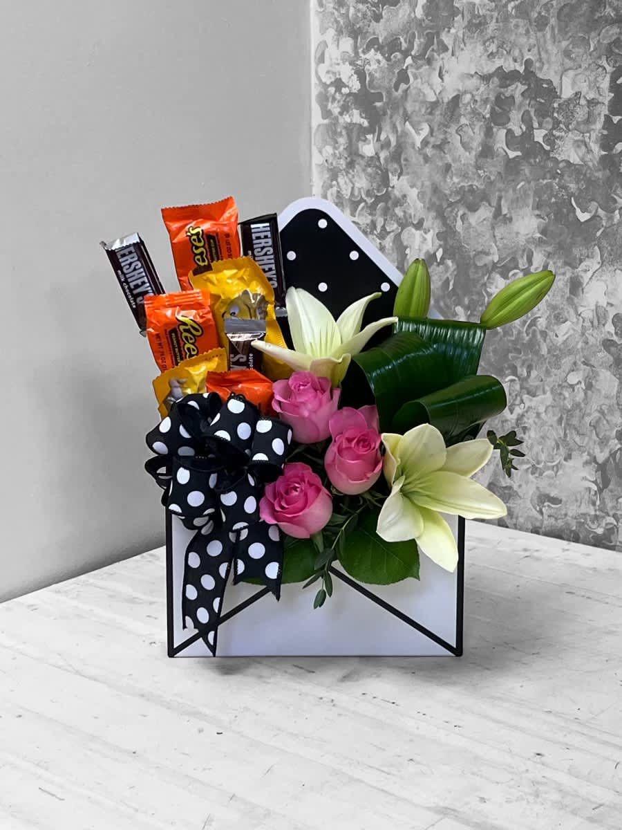 A Little Sassy - The perfect gift for that one that is just a little bit Sassy! Arranged in our Envelope Container with Roses, Lilies and a bouquet of candy. Envelope color may vary.