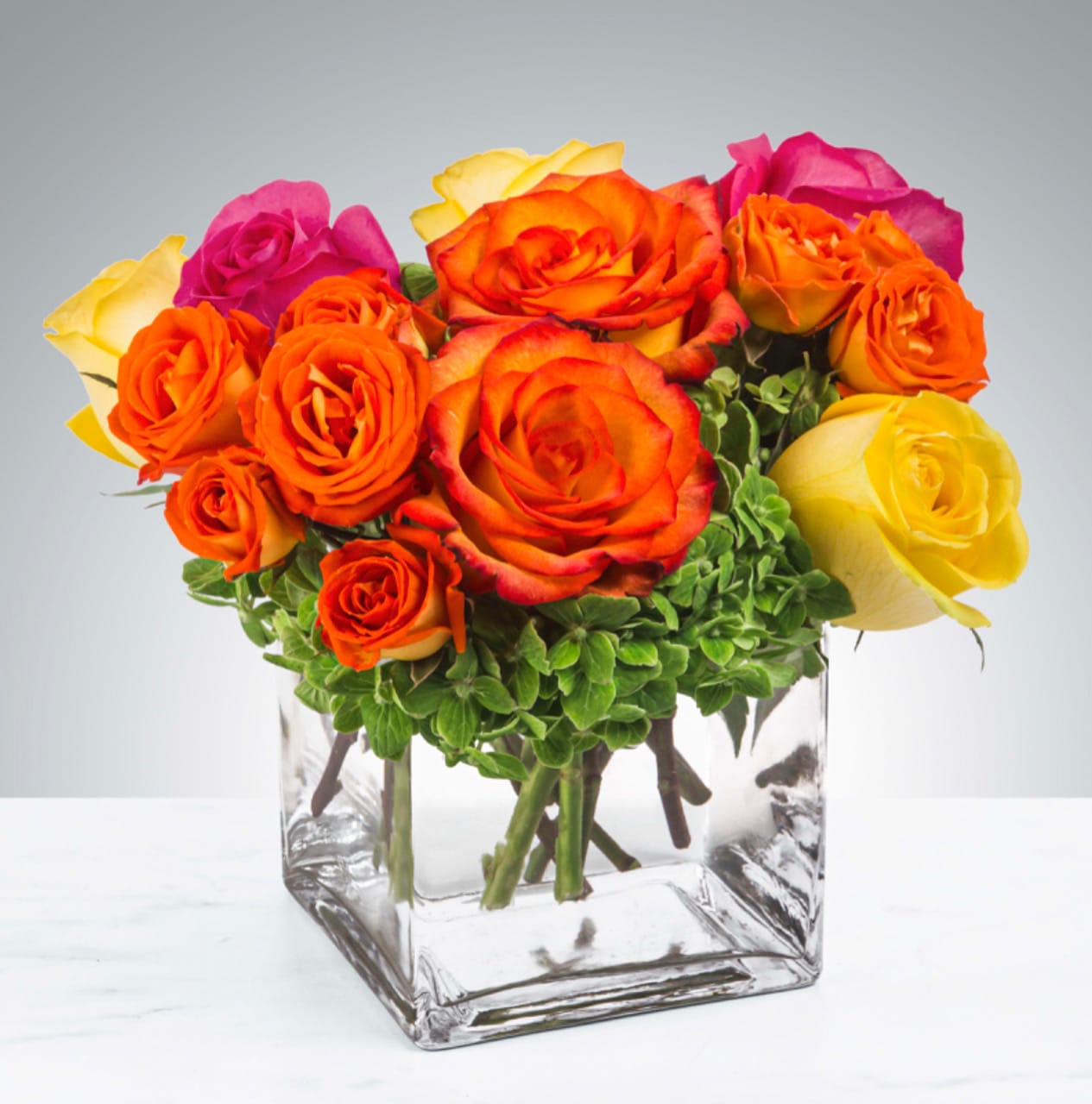 Bright Morning  - Pink, yellow and orange roses come together with green hydrangea for a bright cube of sunshine. This arrangement lights up any space and will improve anybody's day. A perfect gift for all occasions.   APPROXIMATE DIMENSIONS 10" W X 11" H 