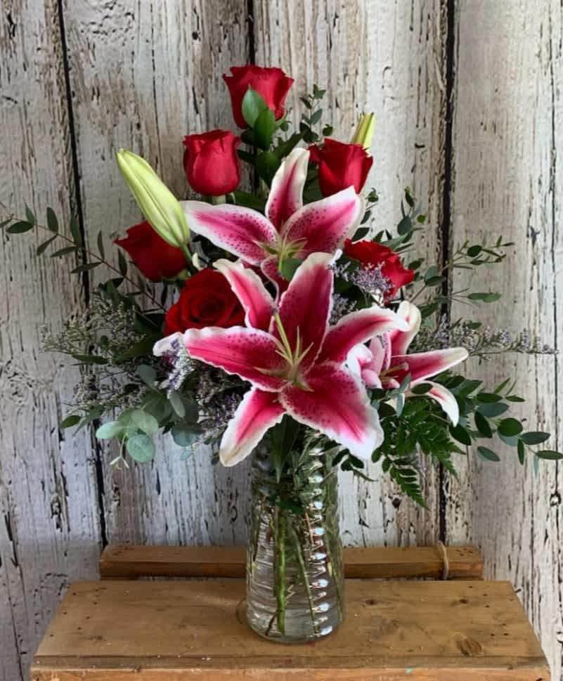 Pretty Like You! - This pretty arrangement is sure to please this Valentine’s Day. Designed tall with half dozen roses, fragrant lily and premium greens. Style may vary for glass vase may vary due to hardware availability.  