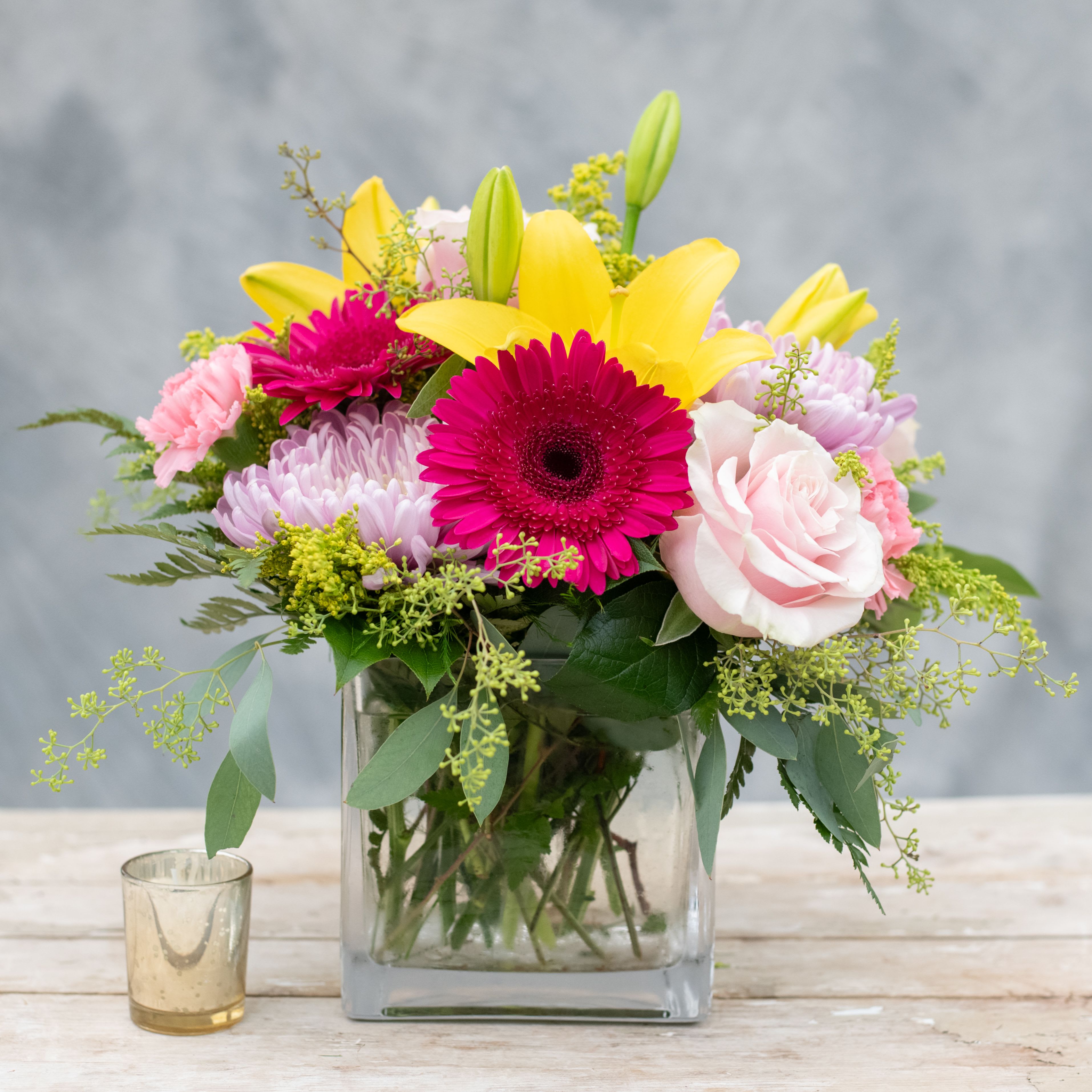 Caribbean Twist - Bring this little taste of Caribbean colors into your home or office from the bright yellow lilies to the hot pink gerbera daisies and the pink roses.  