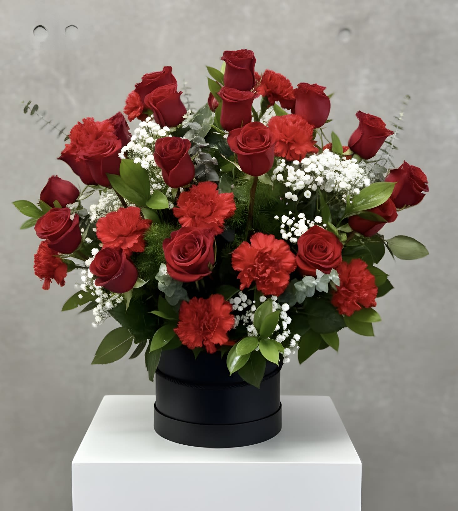 Passionate Rose Petals  - Immerse yourself in the intoxicating beauty of the arrangement, where deep red roses and carnations intertwine with lush greenery to create a breathtaking display of romance and desire. STANDARD 18 ROSES DELUXE 24 ROSES PREMIUM 36 ROSES
