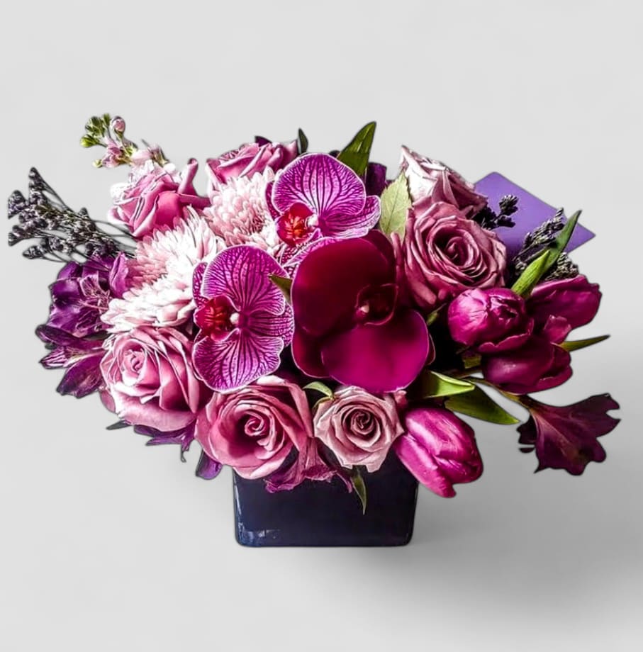 Violet Flowers Beautiful Bouquet Designer's Choice - Please call first for availability. Please allow 48 hours notice.  Made unique and different each time from my beautiful blossom selection of that day. Perfect for every occasion. Send this beautiful bouquet today with it's beautiful violet blossoms of that day roses orchids and more in a modern, black glass cube vase. All fresh flower arrangements that leave my flower studio are beautiful works of art. Please check out my beautiful gallery. Send them a beautiful bouquet to make them smile.