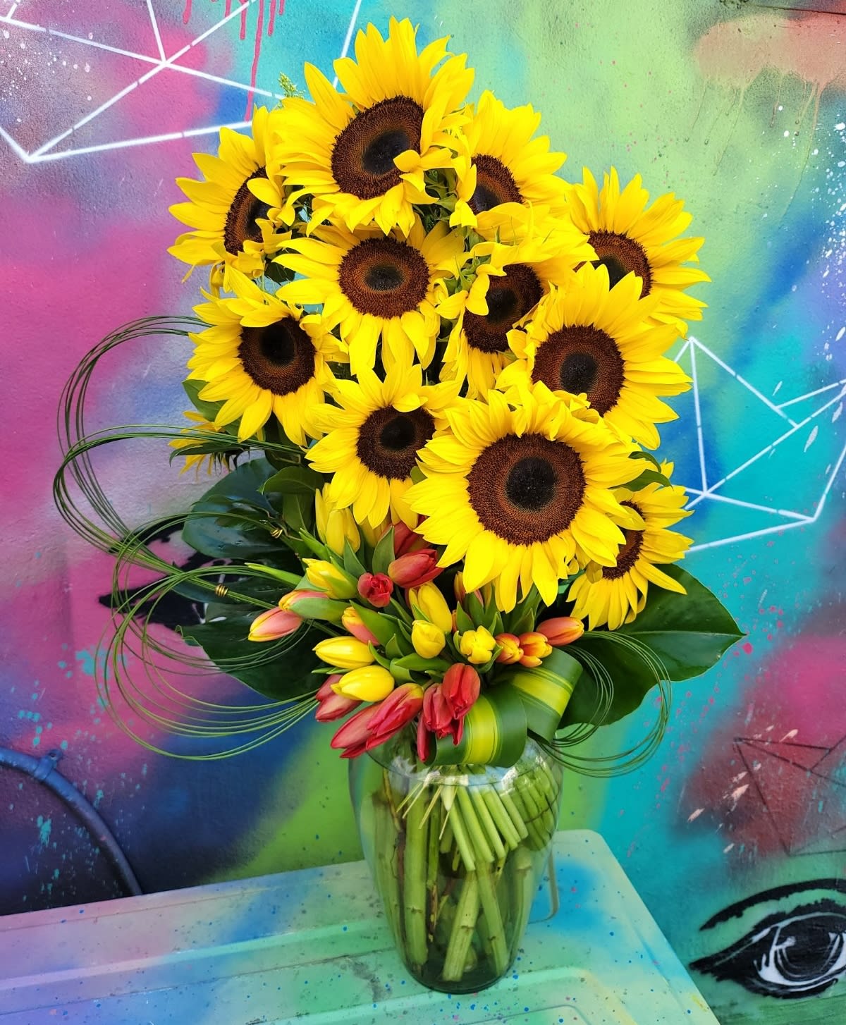 Sunflowers - An arrangement in a clear vase made of sunflowers, Lillies, and greenery    This arrangement needs 24 business hrs to compete