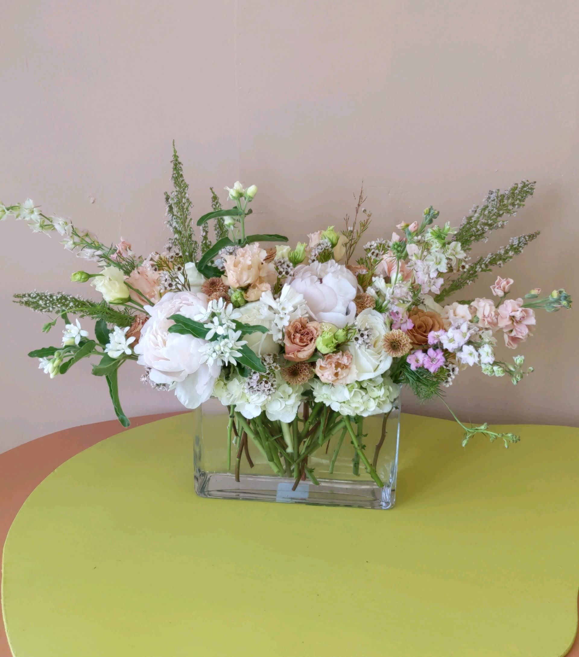 Neutral Ambiance  - Neutral blooms in a glass rectangular vase ideal for any occasion. 