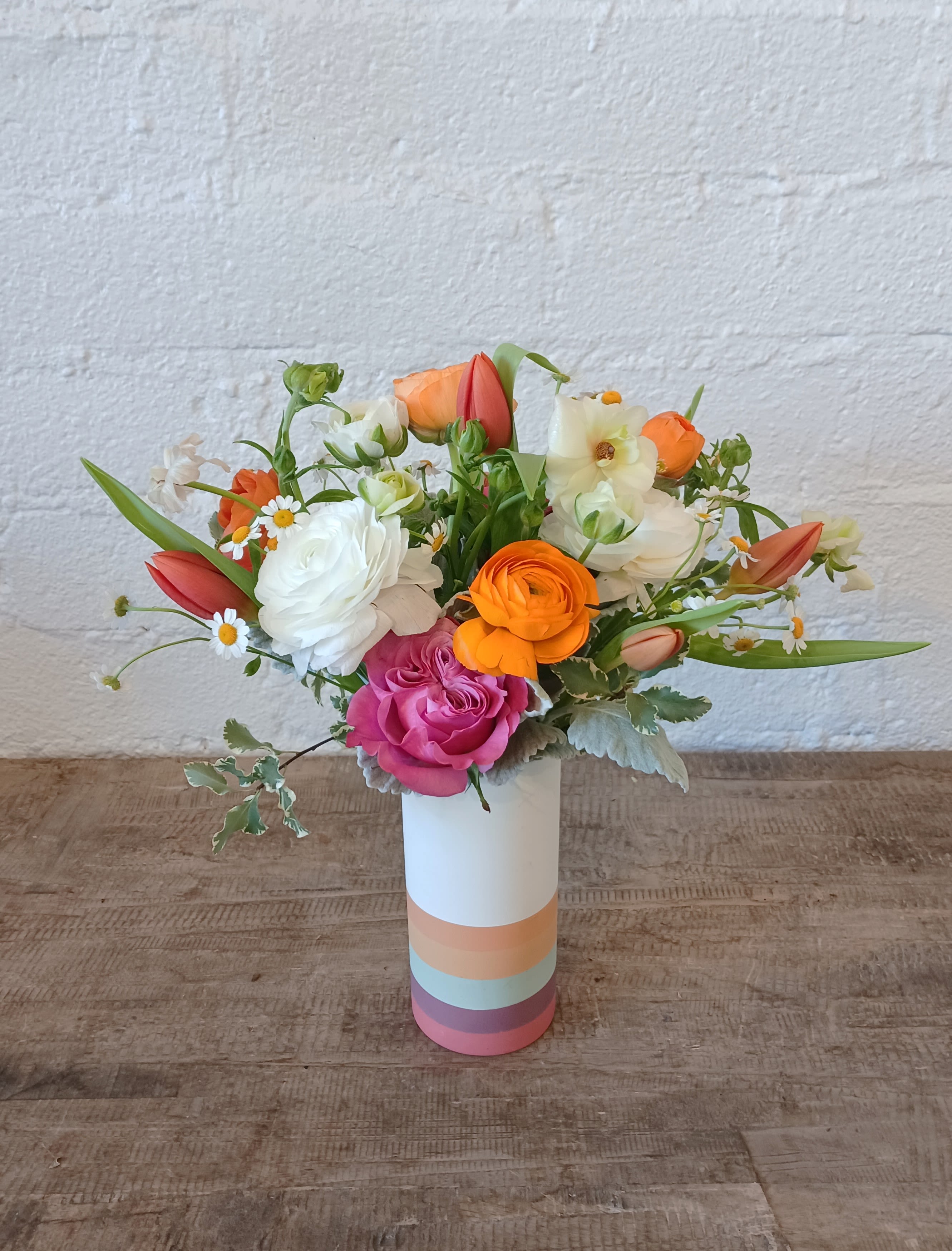 The Ranunculus Lover   - The perfect arrangement for any Ranunculus lovers out there! This simple yet springy arrangement is comprised mostly of different colored Ranunculus, tulips and hyacinth and some simple fillers. Arrangement comes in a ceramic vase.