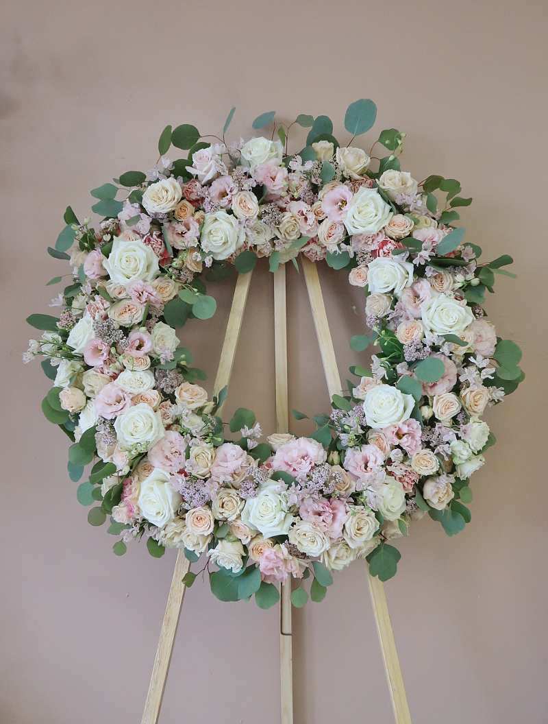 Softener of Hearts Wreath  - A standing 24 inch diameter Wreath on a wooden easel (included) with premium flowers like, lisianthus, garden spray roses, roses and silver dollar. Colors are customizable. DISCLAIMER: The "Standard" option DOES NOT include a ribbon. If you would like to include a ribbon select the "Deluxe" option and in the special instruction box let us know what you would like the ribbon to say. 