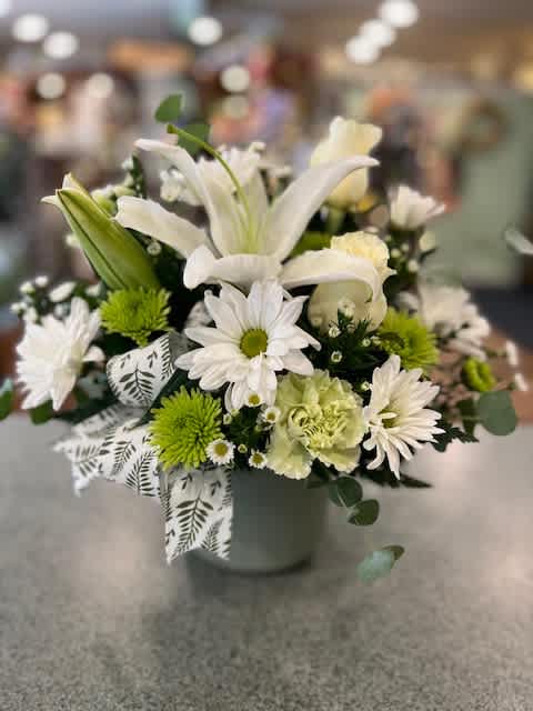 Serene Green (SG) - A tranquil design of Green and White flowers such as lilies, roses and button mums in a two tone ceramic pot.  A beautiful gift