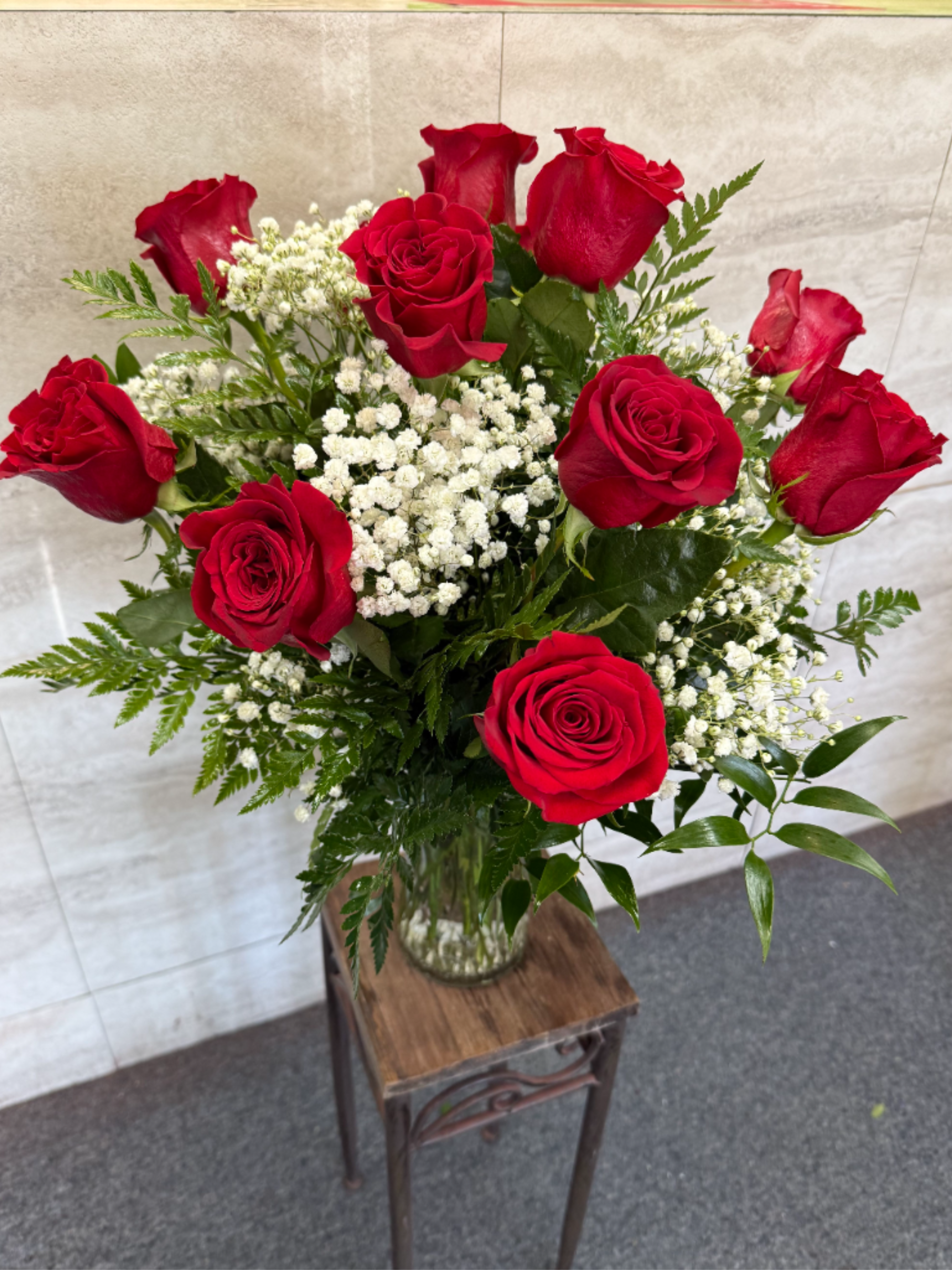Dozen's red roses - A classic arrangement of vibrant red roses accented with delicate baby’s breath and fresh greenery, elegantly displayed in a clear glass vase—perfect for expressing love, admiration, or celebrating any special occasion. 
