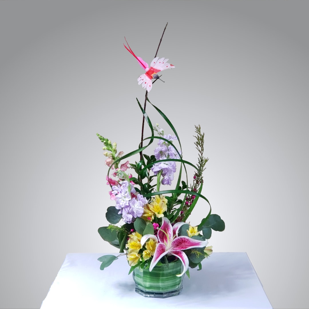 Bird Song - Swirling lily grass gracefully flows upward through a field of fresh flowers. An inspiring, sculpted design that makes a wonderful gift for that special person in your life. Bird color varies.