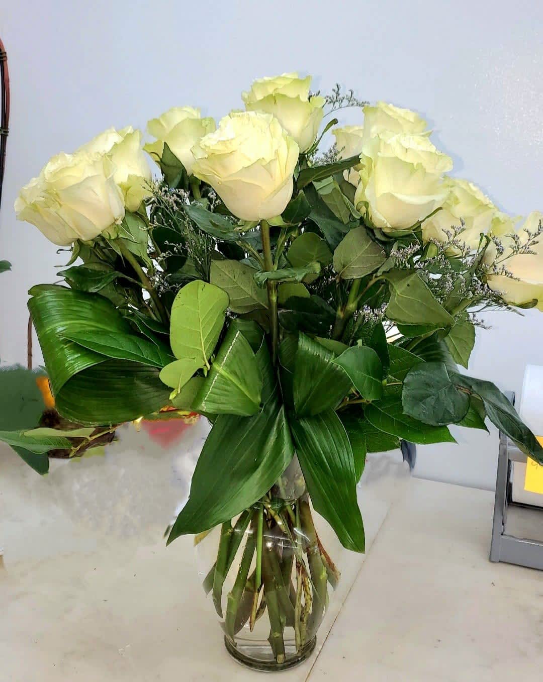 Classic White Roses - The classic will always be the best.  Roses in Designer Quality. Rose color can be changed to Pink, red, Yellow etc.  12 dozen Roses. Greenery. Vase