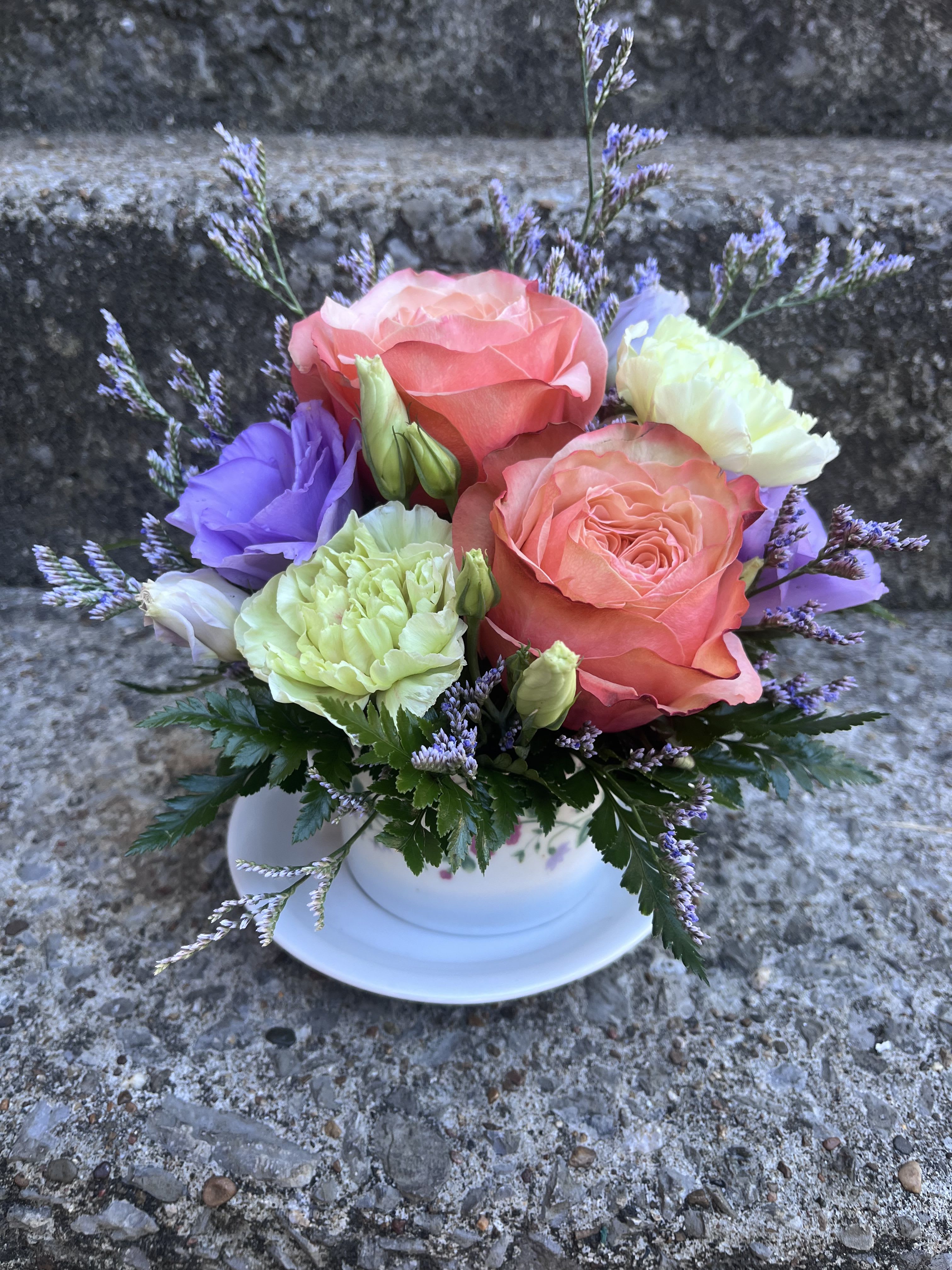 Peaches And Cream Coffee Cup - This arrangement has roses , limonium , lisianthus, carnations and greenery.