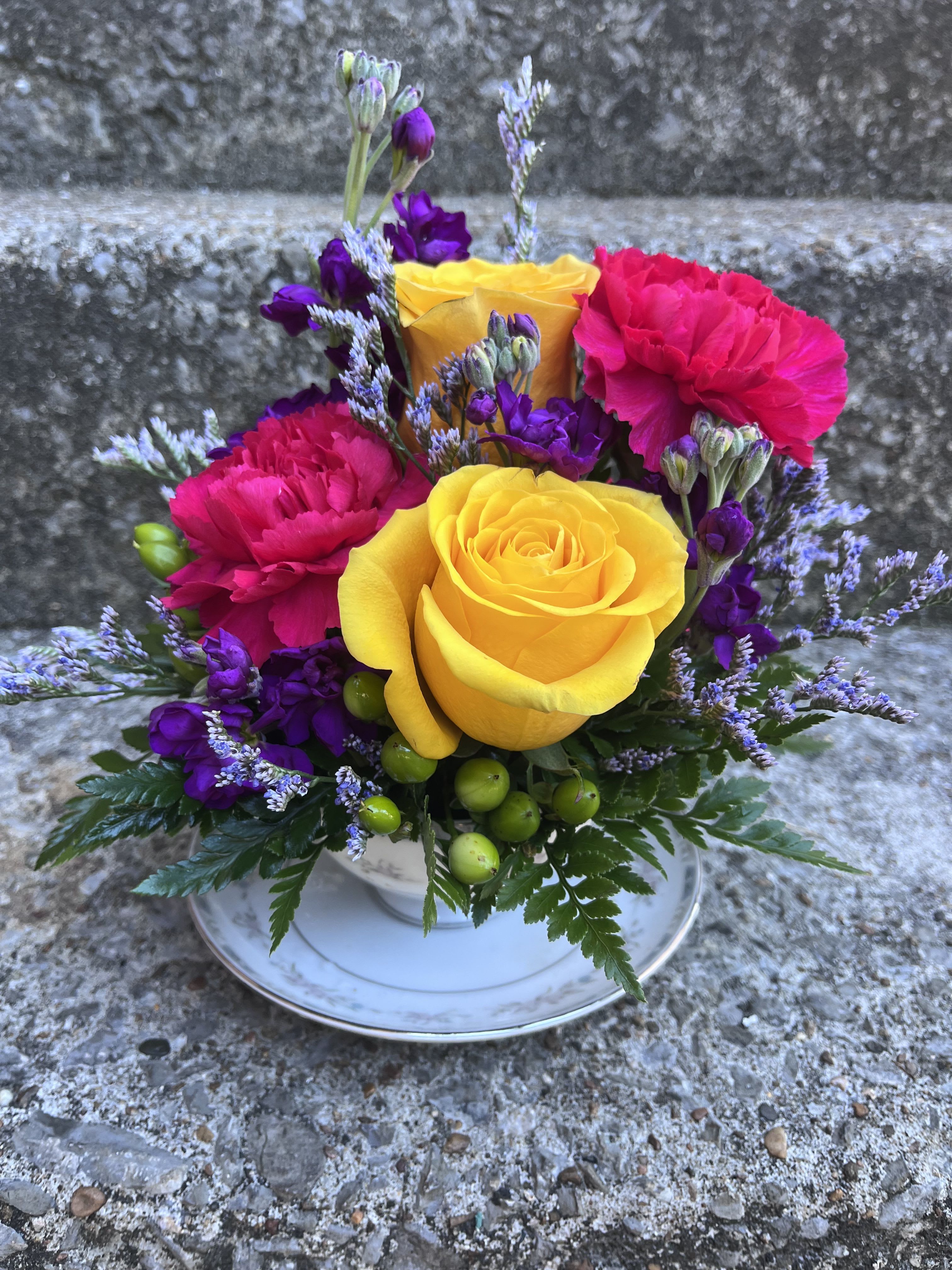 Sipping Paradise Tea Cup - This arrangement has roses, stock, hypericum, limonium, carnations and greenery. 
