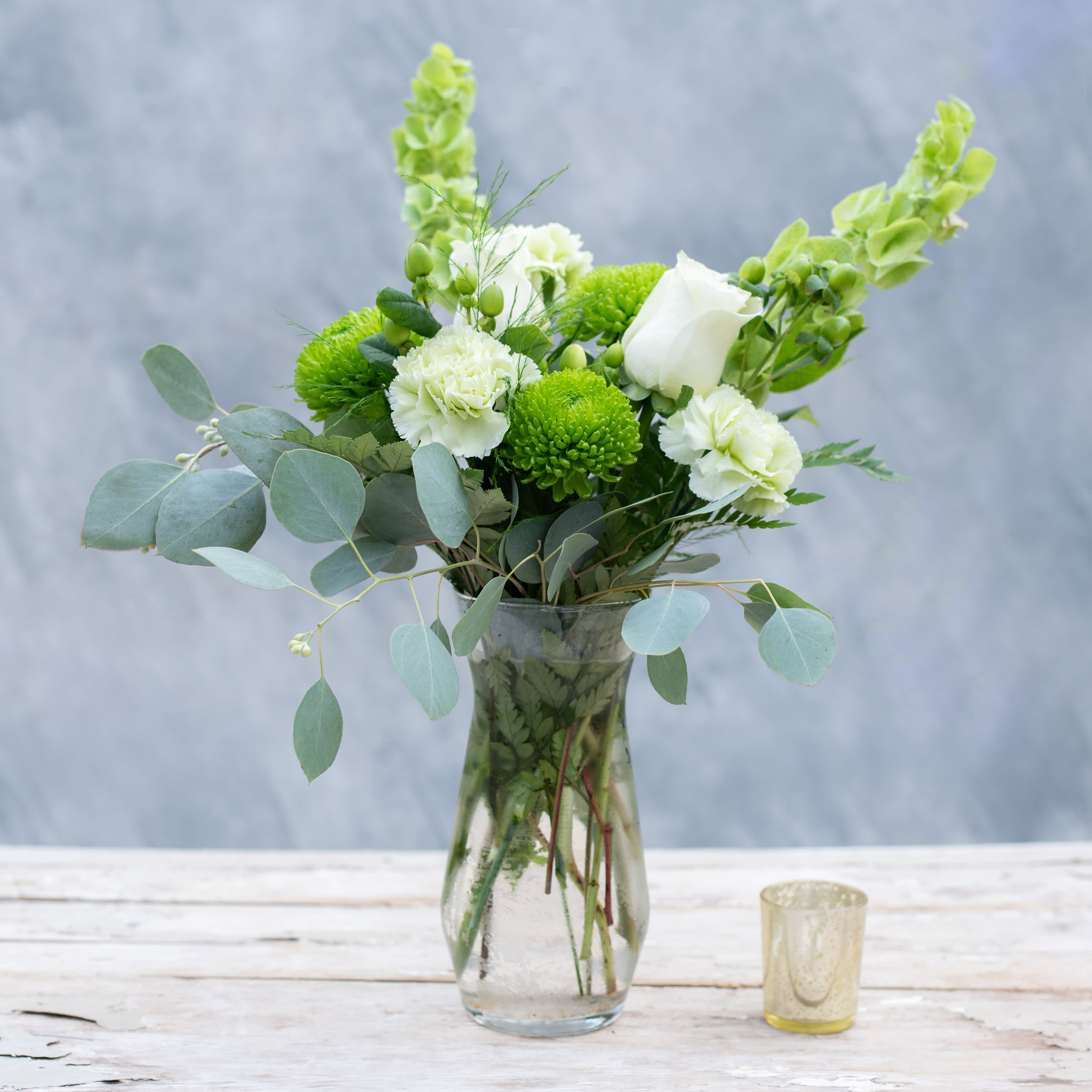 Irish Eyes - Celebrating St Patty's Day? Know someone of Irish descent? Send this lovely green and white beauty, a simple glass vase filled with white roses, green carnations, white mums and topped off with Bells of Ireland.