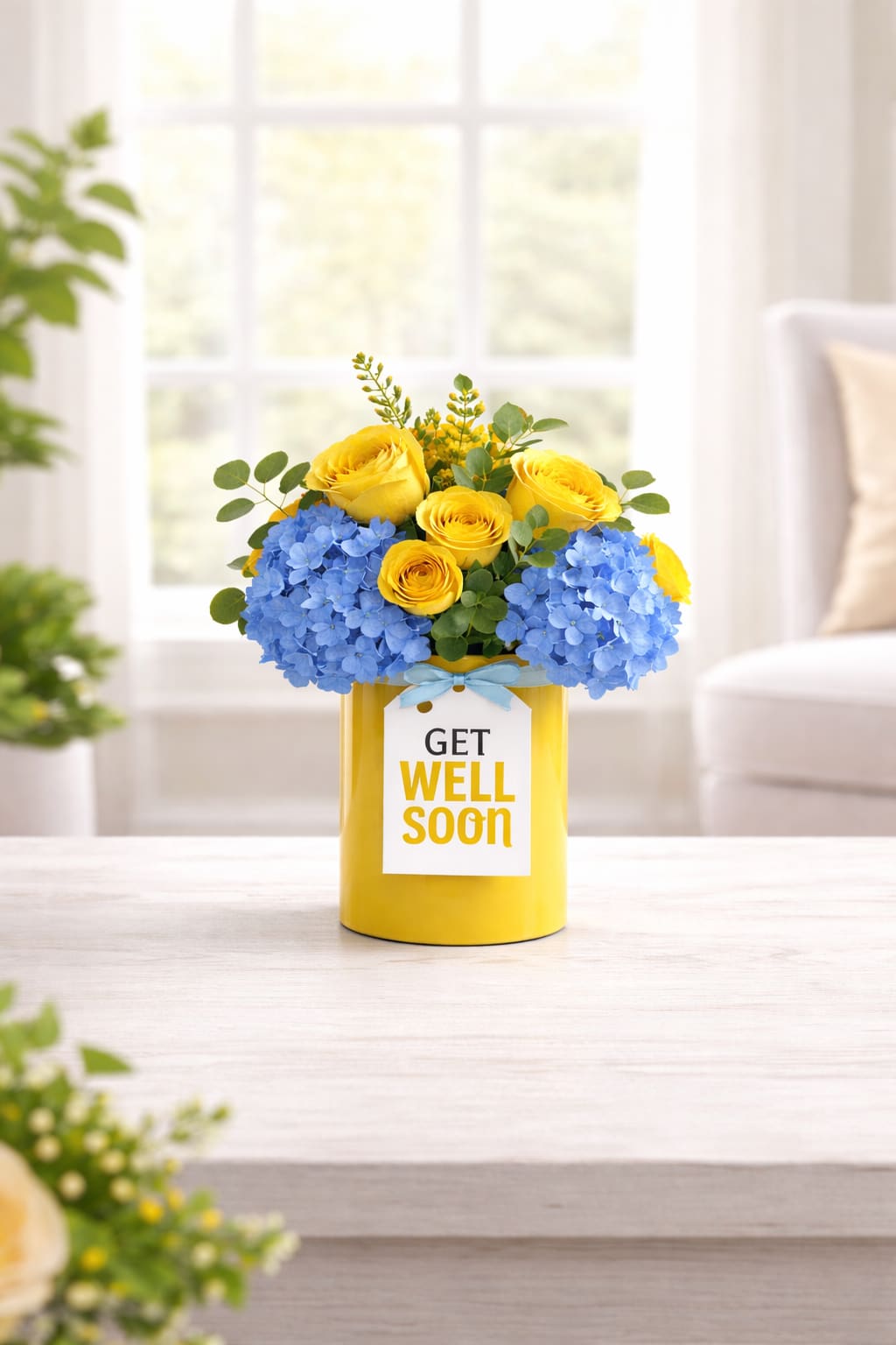 Bloom Therapy  - Bloom Therapy is a vibrant burst of joy designed to lift spirits and brighten any room. Featuring radiant yellow roses, bold blue hydrangeas, and soft greenery, this cheerful bouquet is artfully arranged in a sunny yellow vase with a sweet “Get Well” tag tied in a satin blue ribbon. Whether you're sending warm wishes for a speedy recovery or simply hoping to bring a smile, Bloom Therapy delivers comfort, color, and care in one beautiful package.  Perfect for hospitals, homes, or heartfelt surprises — let your love bloom with every petal.