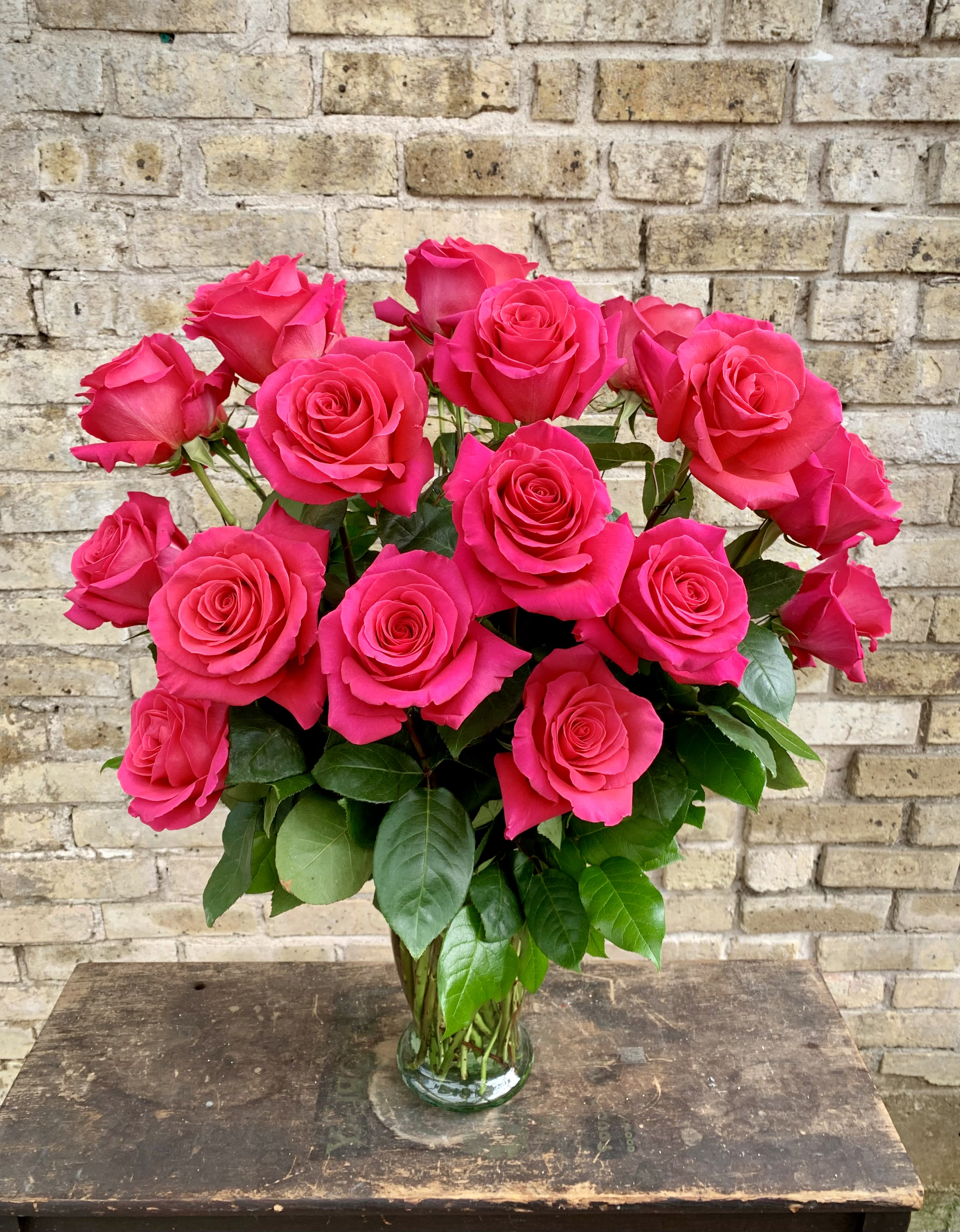 Cerese - 18 Beautiful Hot Pink Color Roses Arranged in a Clear Glass Vase With Greens. Simply Gorgeous !