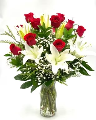 Romance Of Roses And Lilies - This Romantic Bouquet includes fresh white lilies and vibrant red roses. Accented with greens, this bouquet makes a great gift or decoration for any loved one! This bouquet is one that will be remembered for a long time!