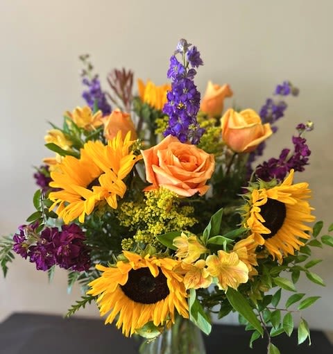 Ray of Sunshine - Bright and happy, sunflowers, roses, and purple florals. Just like a ray of sunshine!   *Flowers subject to change based on supply*
