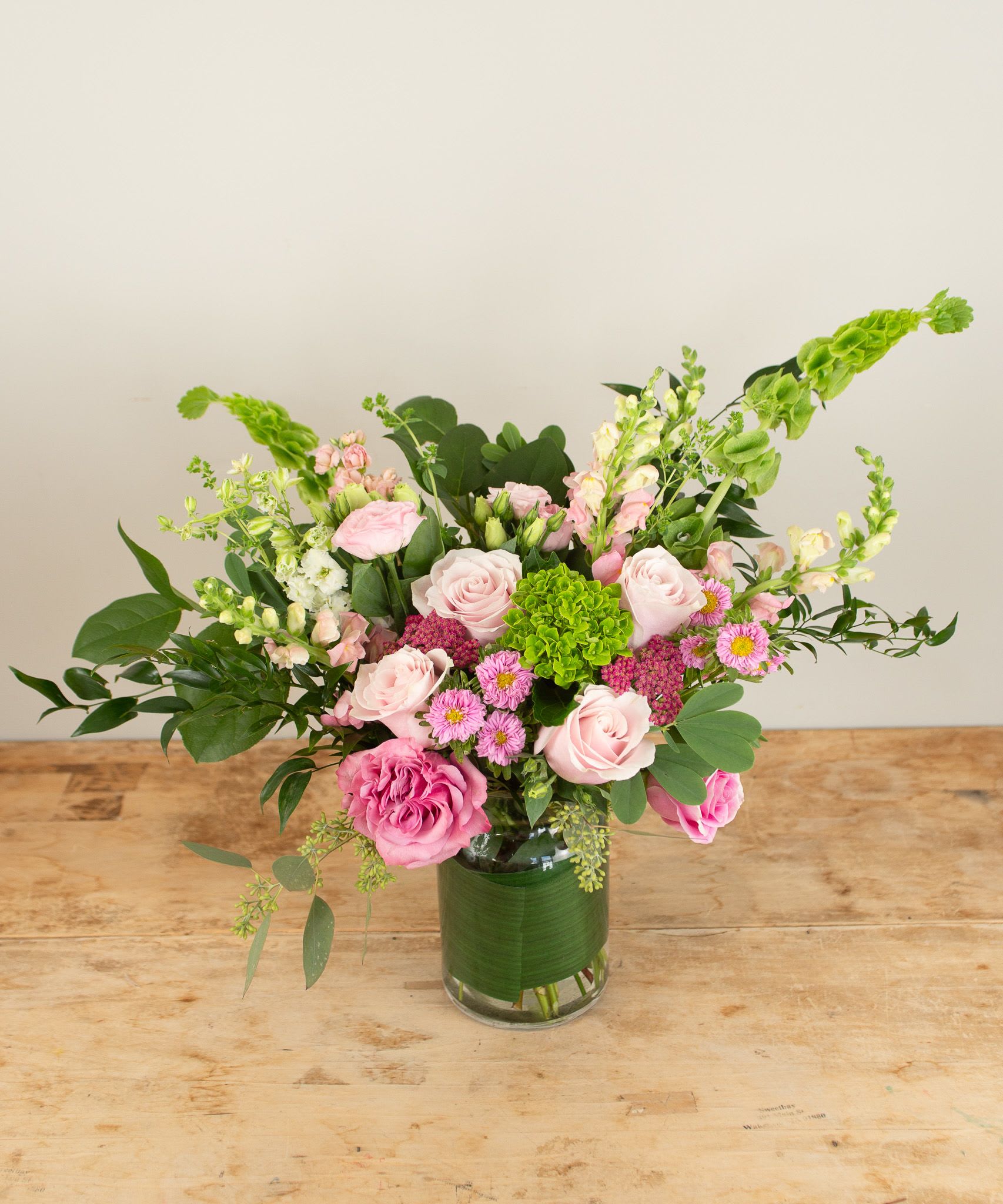 Grace &amp; Bloom - A graceful blend of soft pinks, lush greens, and fresh seasonal blooms, this tall arrangement offers a gentle expression of care and comfort. Whether you're sending love during a difficult time or simply letting someone know you're thinking of them, this bouquet speaks from the heart.  Size shown is the deluxe at approximately 24"x 14" 
