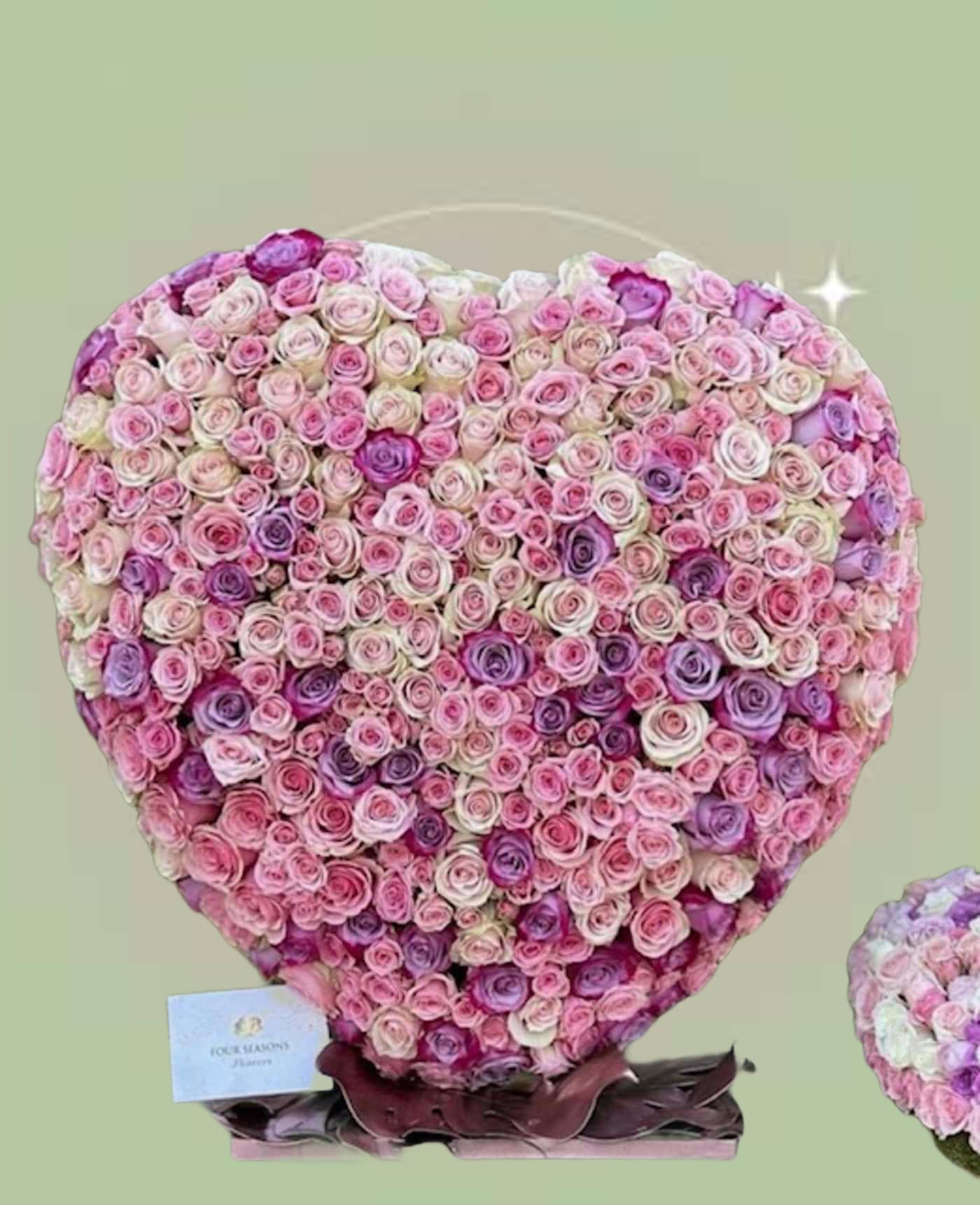 Pastel Ombre Floral Standing Heart - A beautifully arranged standing floral heart, crafted in a full, symmetrical heart shape using layered blossoms. A lush and textured surface that gives the piece depth and dimension. Soft pink and lavender tones blend throughout the arrangement, producing a gentle ombre effect that transitions between lighter blush shades and slightly deeper pink hues. Delicate petals form a romantic and elegant statement piece. Ideal for proposal, birthdays, Valentine’s décor, anniversaries, or gift displays   Please note: Due to the grand scale and premium blooms used in this arrangement, advance ordering is highly recommended to ensure availability and optimal design execution.  Some florals are seasonal, if particular flower will not be available due to season, we will substitute for similar flower, composition, color pallet and value of the arrangements as closely as possible. All effort to create a floral arrangement as close to the photo shown, the actual arrangement may vary slightly in its appearance from the photo shown. If you have any questions about your order, we welcome you to call us in or email  Holiday Delivery:  Same-day delivery available. Deliveries are made throughout the day based on routing.  