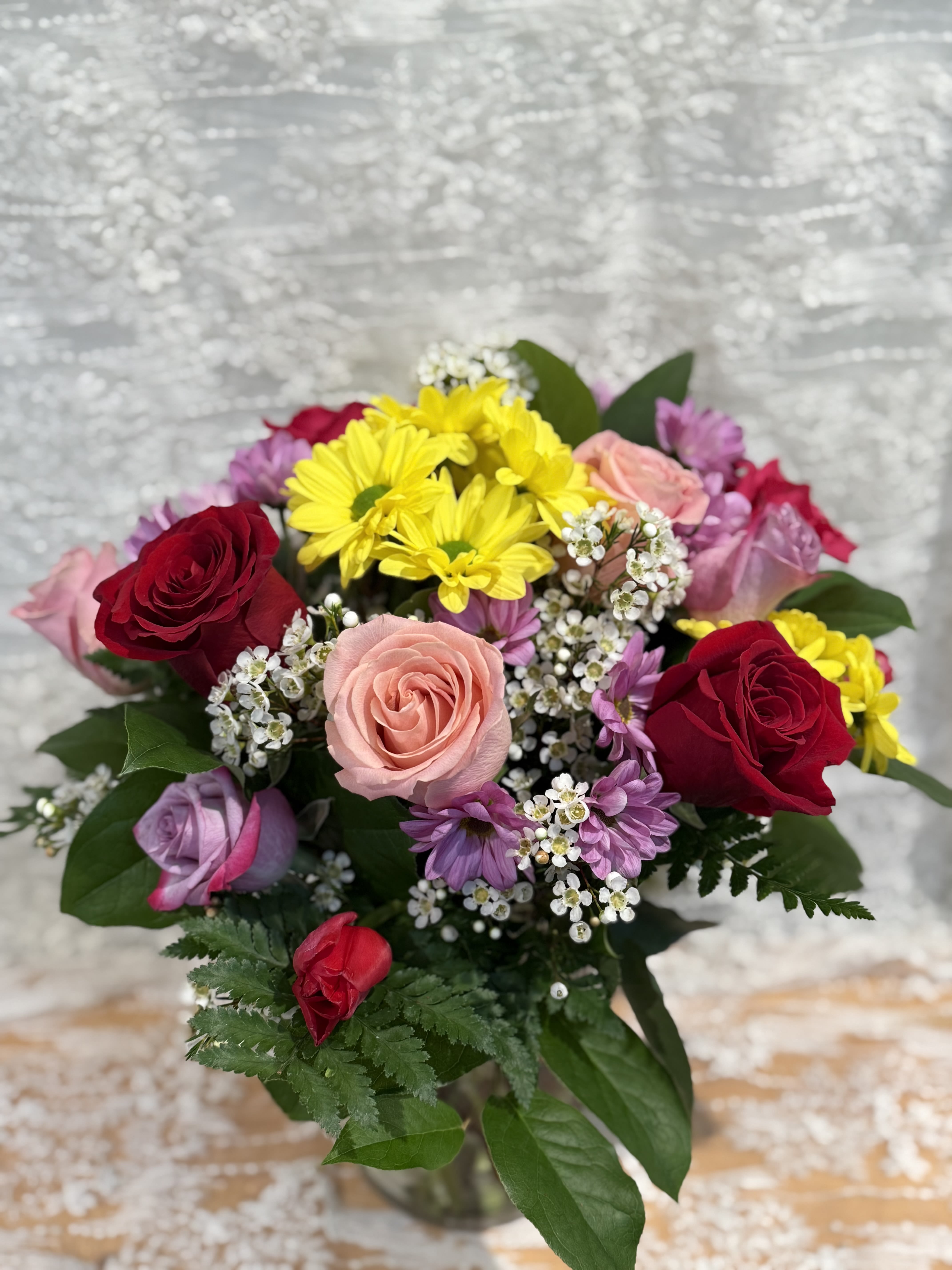 Happy Face - Mix colorful arrangement with in stock flowers  Picture arrangement has roses, mums, tulips and wax flower with greenery