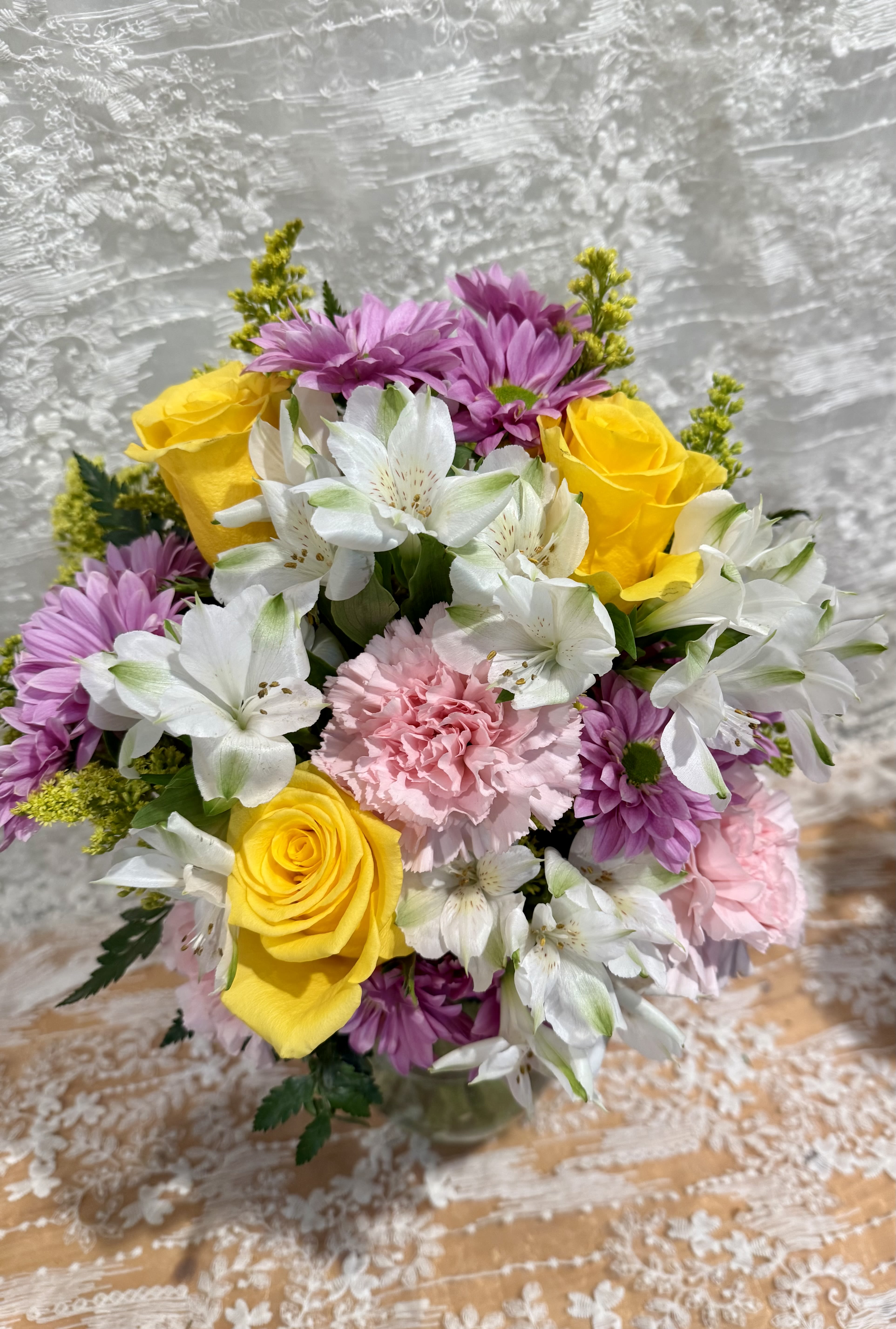 Springtime - Bright mix bouquet filled with yellow roses, pink carnations, lavender mums and white alstroemeria 