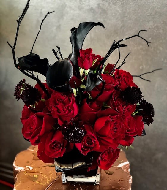 Dark Romance Floral Arrangement - An alluring and abstract composition infused with passion, Midnight Noir features striking black calla lilies admired for their sculptural shape and rich texture. Accented with black scabiosa, deep red roses, and dramatic black branches, this modern arrangement creates a bold, mysterious statement and sets an unforgettable mood in any space.    Some florals are seasonal, if particular flower will not be available due to season, we will substitute for similar flower, composition, color pallet and value of the arrangements as closely as possible. All effort to create a floral arrangement as close to the photo shown, the actual arrangement may vary slightly in its appearance from the photo shown. If you have any questions about your order, we welcome you to call us in or email      Holiday Delivery:  Same-day delivery available. Deliveries are made throughout the day based on routing.