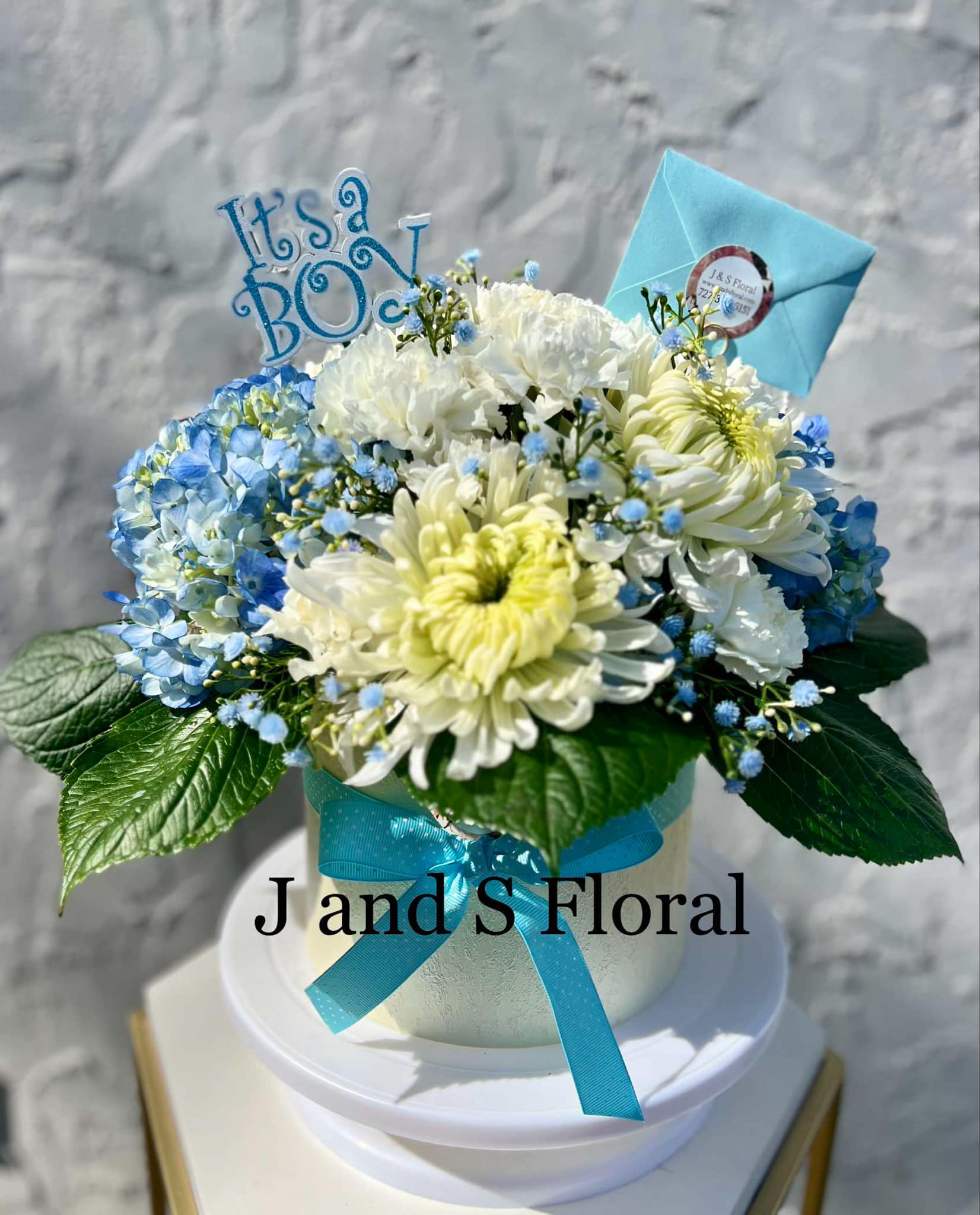 Blue Bundle Of Joy - Celebrate the great news with our handcrafted Baby Boy floral arrangement. Perfect to congrats your loved one on their new bundle of joy!