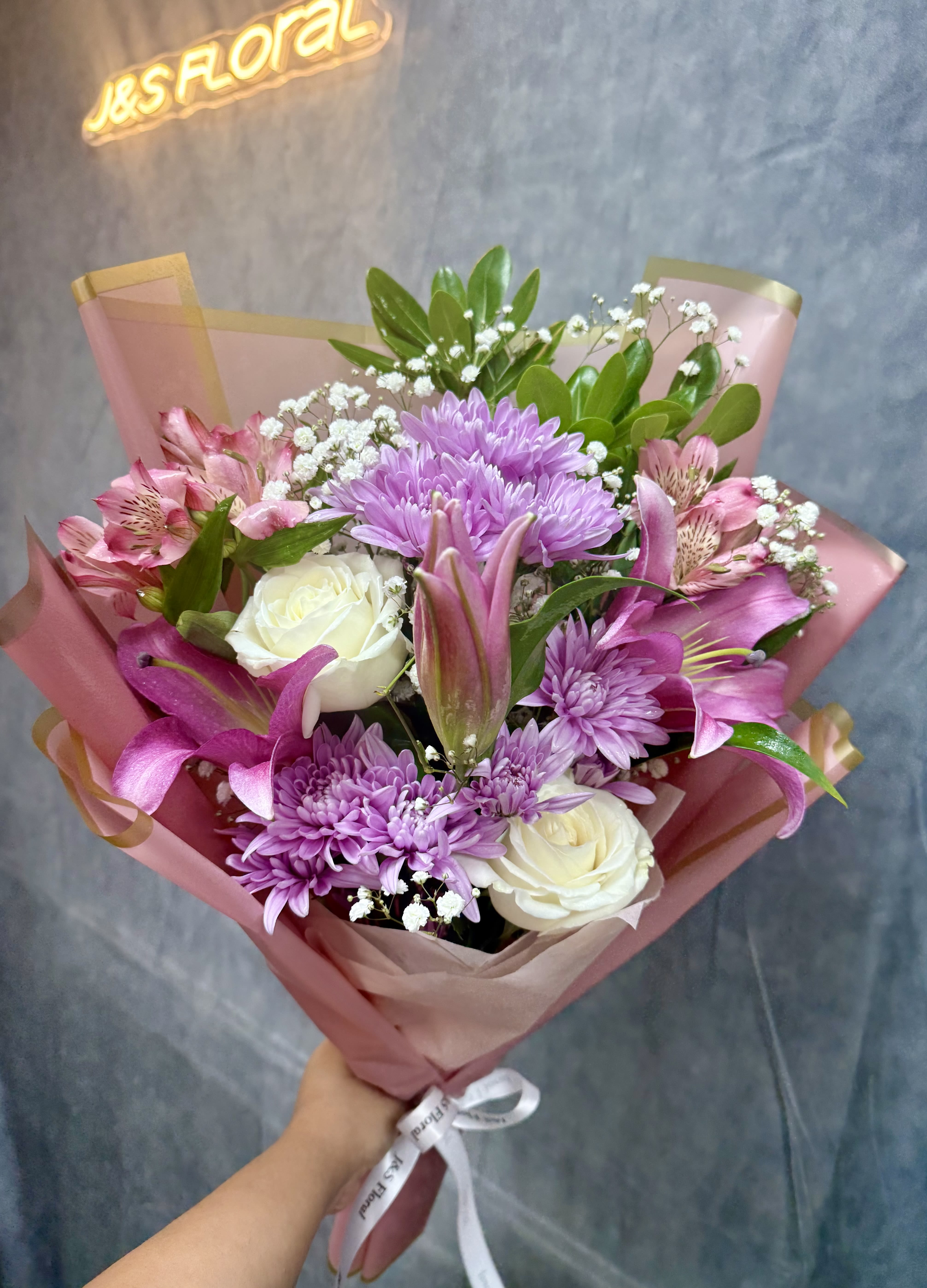 Lavender Kisses - Lavender Kisses Bouquet Delicate and dreamy, our Lavender Kisses bouquet features graceful pink lilies, elegant white roses, and a mix of soft-hued blooms, creating a romantic arrangement full of charm and serenity.