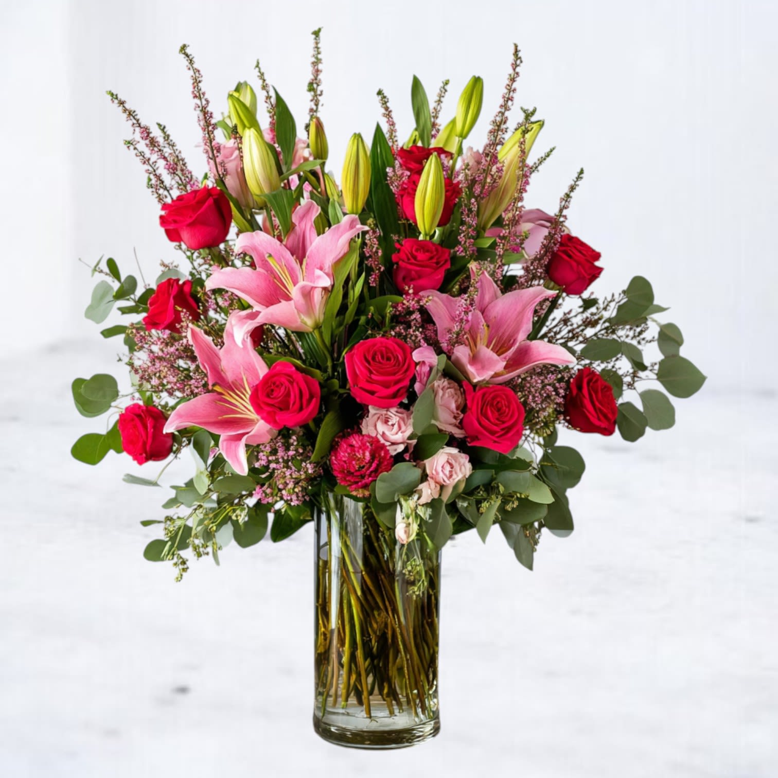 Full Bloom - Full Bloom is a bold, garden-forward arrangement designed at peak expression. Lush roses, lilies, and seasonal blooms are layered with fresh greenery for a look that feels vibrant, intentional, and unmistakably alive. Designed with movement and fullness in mind, this arrangement makes an immediate statement—perfect for celebrating, marking a moment, or simply sending something unforgettable.  Styled in a clear glass vase and finished with a natural, abundant silhouette, Full Bloom delivers color, texture, and presence without feeling overworked.  Flower varieties may vary slightly based on seasonal availability, but the overall palette, scale, and design intent of Full Bloom will always be honored. Each arrangement is crafted with premium blooms to reflect the same fullness and impact shown.