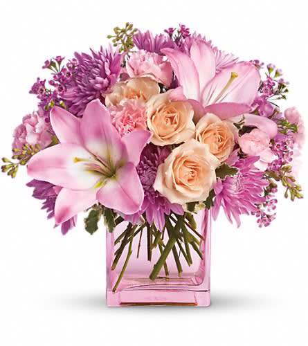 Teleflora's Possibly Pink - Impossibly pretty. This decidedly feminine arrangement is absolutely delightful. Perfectly peachy peach spray roses pink asiatic lilies and miniature carnations lavender cushion spray chrysanthemums and waxflower pittosporum and seeded eucalyptus fill an exclusive pink cube. Have one delivered and almost anything's possible.Approximately 11" W x 10 1/4" H Orientation: One-Sided As Shown : T145-1ADeluxe : T145-1BPremium : T145-1C