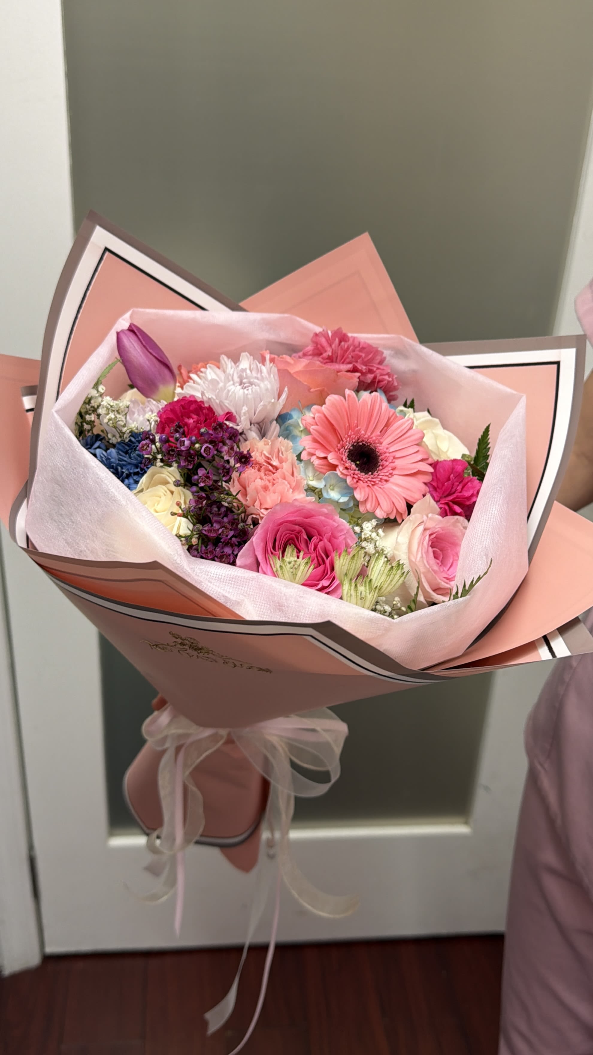 Rainbow  - A charming hand-tied bouquet designed in soft pastel tones with playful pops of color. Featuring delicate pink gerberas, lush roses, hydrangea, chrysanthemums, tulip accents, and textured fillers for depth and movement. Wrapped in blush pink paper for a refined and romantic finish, this bouquet is perfect for birthdays, celebrations, or simply brightening someone’s day with beauty and joy. 