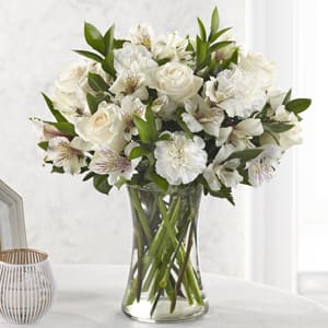 Cherished Friend Bouquet - Honor the memory of your loved one with soft ivory roses, alstromeria, and carnations set against verdant ruscus and leatherleaf. The Cherished Friend bouquet is modern update to a classic funeral arrangement.
