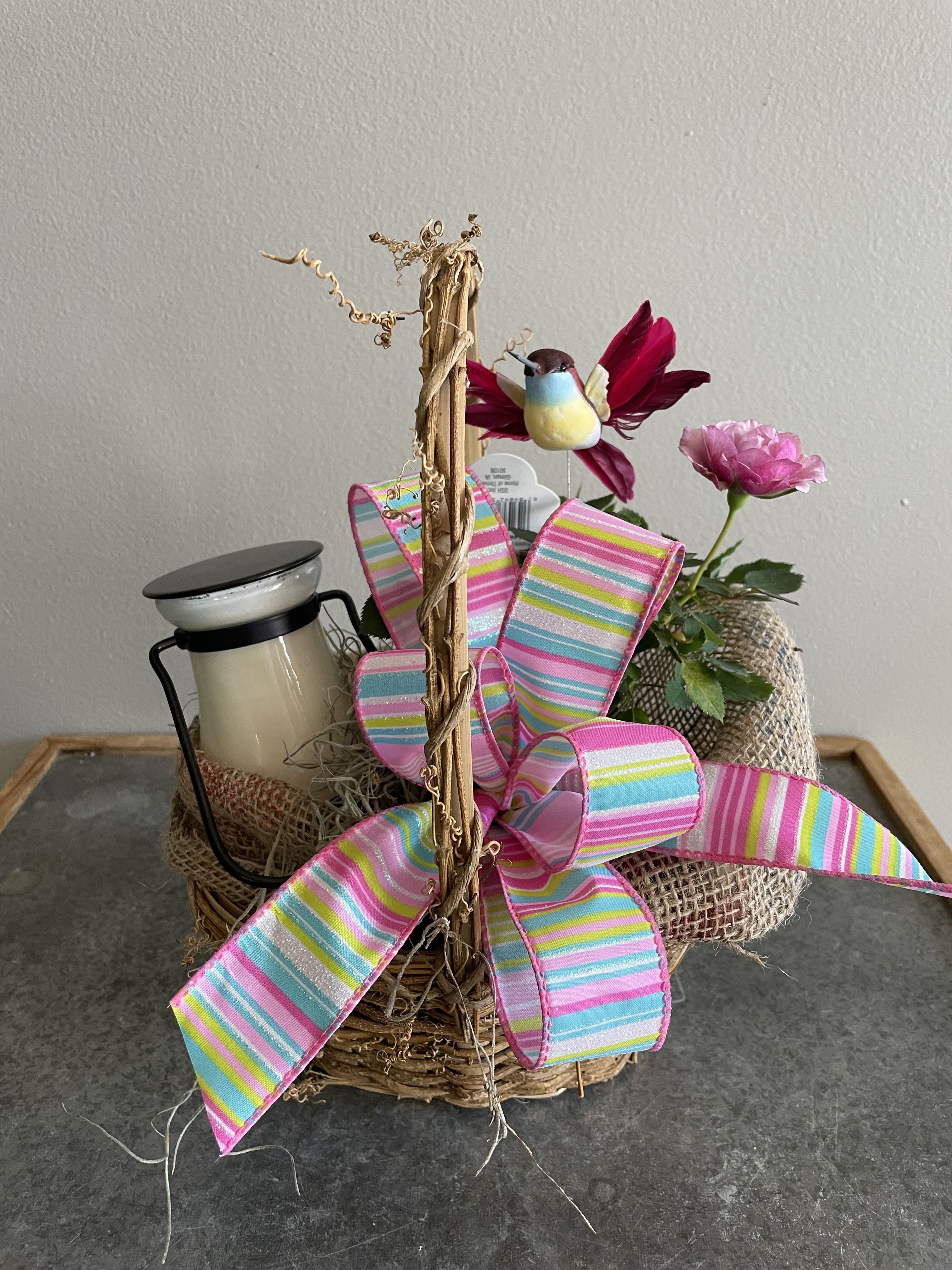 Glowing Garden - Nothing better for a garden lover then this adorable basket. This basket is filled with a 14 ounce 100% Soy Candle from Milk House with a miniature rose bush and accented with burlap and a cute spring humming bird. Perfect for any occasion and a rose that can be planted outside.