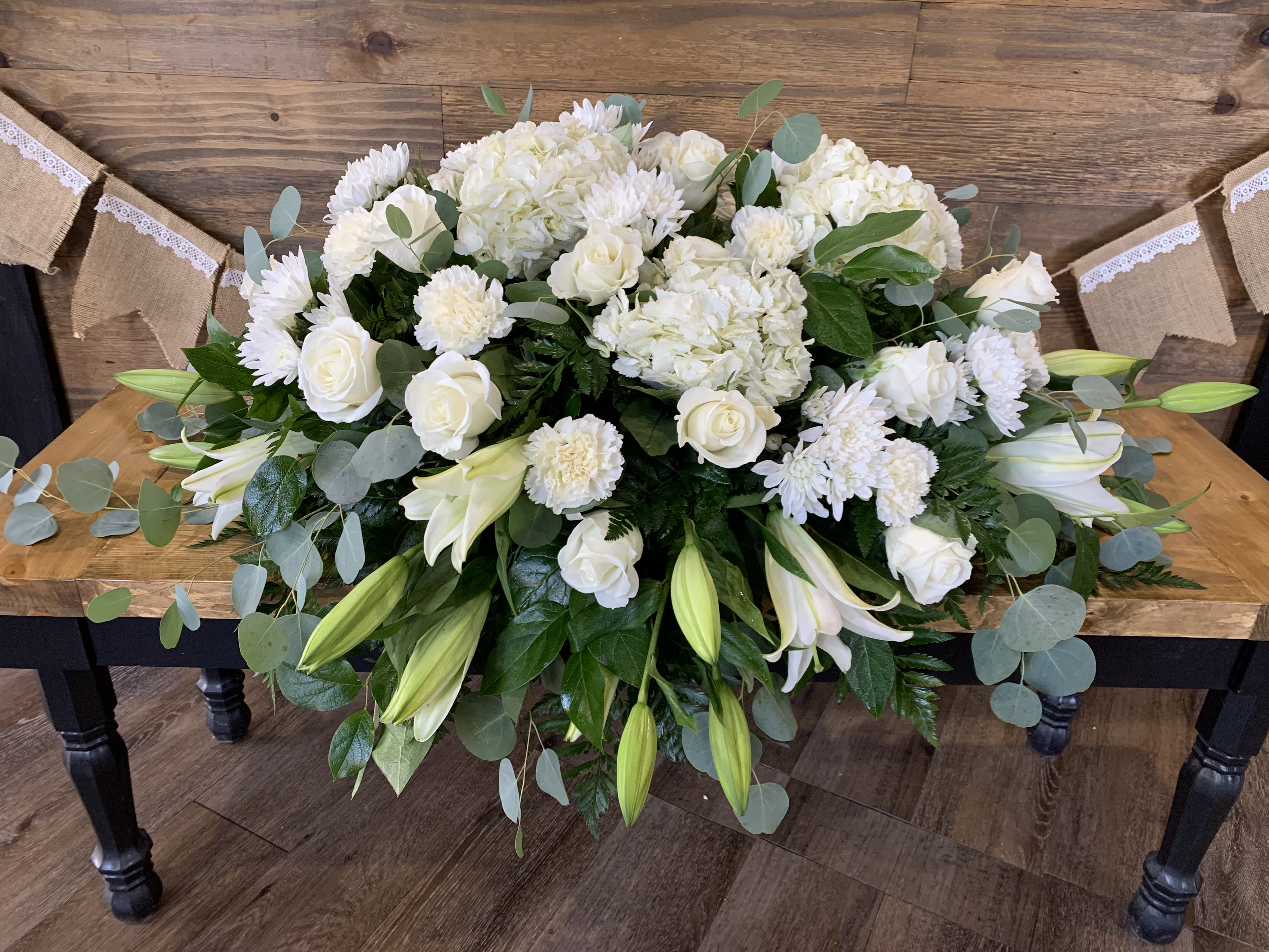 Peace - An all white tribute, this half casket spray is pure in color and heart. Featuring a variety of white flowers and greenery, this elegant half casket spray compliments the beauty of life. 