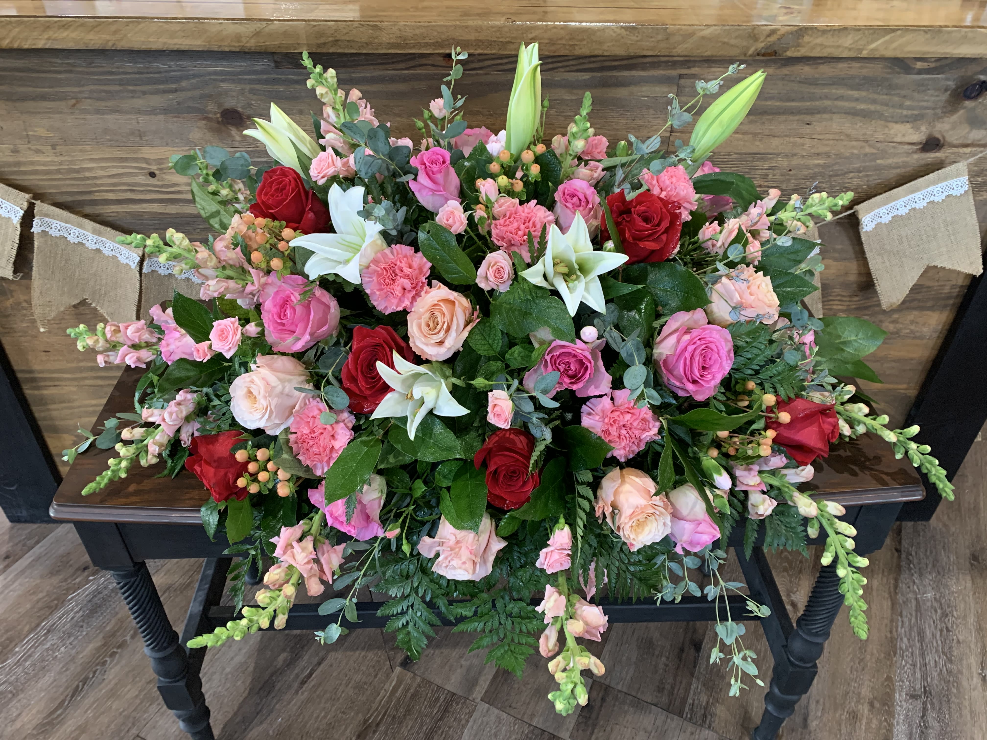 Amazing Grace Casket Spray - A beautiful mix of whites, pinks and red flowers make up this casket spray.
