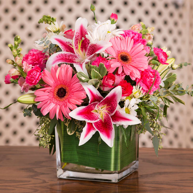 Pink Lady - Stargazer lilies, gerberas, daisies, and greenery in a cubed glass vase. 