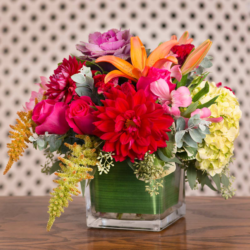 Dramatic Statement - Orange Lilies, Purple Kale and Green Hydrangea in a cubed glass vase.