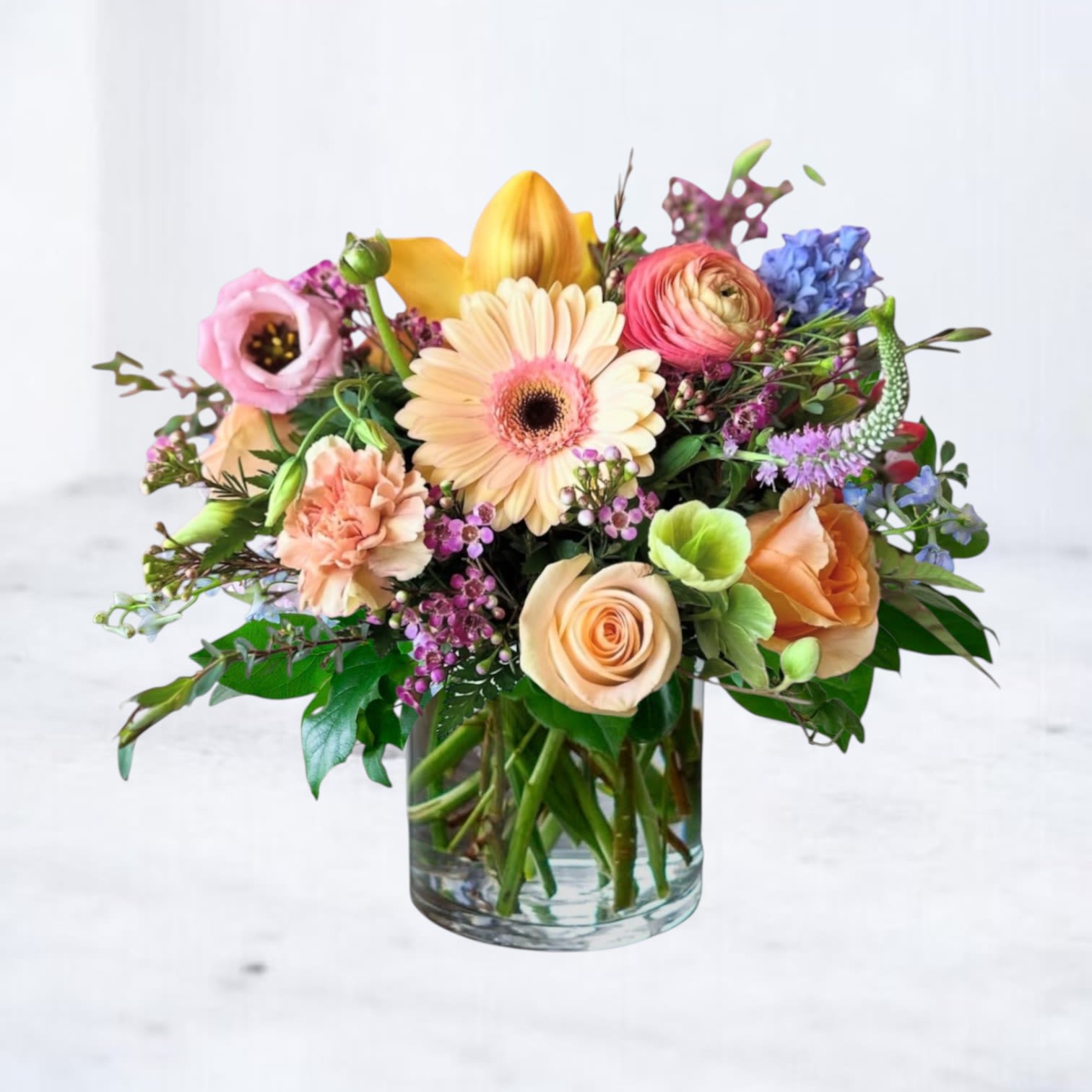 Candy Pastille - The Candy Pastille Bouquet is a cheerful garden medley bursting with joyful color and texture — a perfect choice for birthdays, get-well wishes, thank you gifts, or simply to brighten someone’s day. Featuring a lively blend of soft peach Gerbera daisies, sunshine yellow calla lilies, lush peach and blush roses, pink ranunculus, vibrant hyacinth, waxflower, and playful veronica, this compact and charming bouquet feels like a sweet confection of nature.  At Twigs and Blooms, every arrangement is made to order using premium fresh flowers. If certain blooms are unavailable due to seasonality or supply chain factors, our experienced designers will select beautiful alternatives of equal or higher value while maintaining the original style and color palette of your selected design. Rest assured that your arrangement will always delight and reflect the spirit of your chosen gift.  