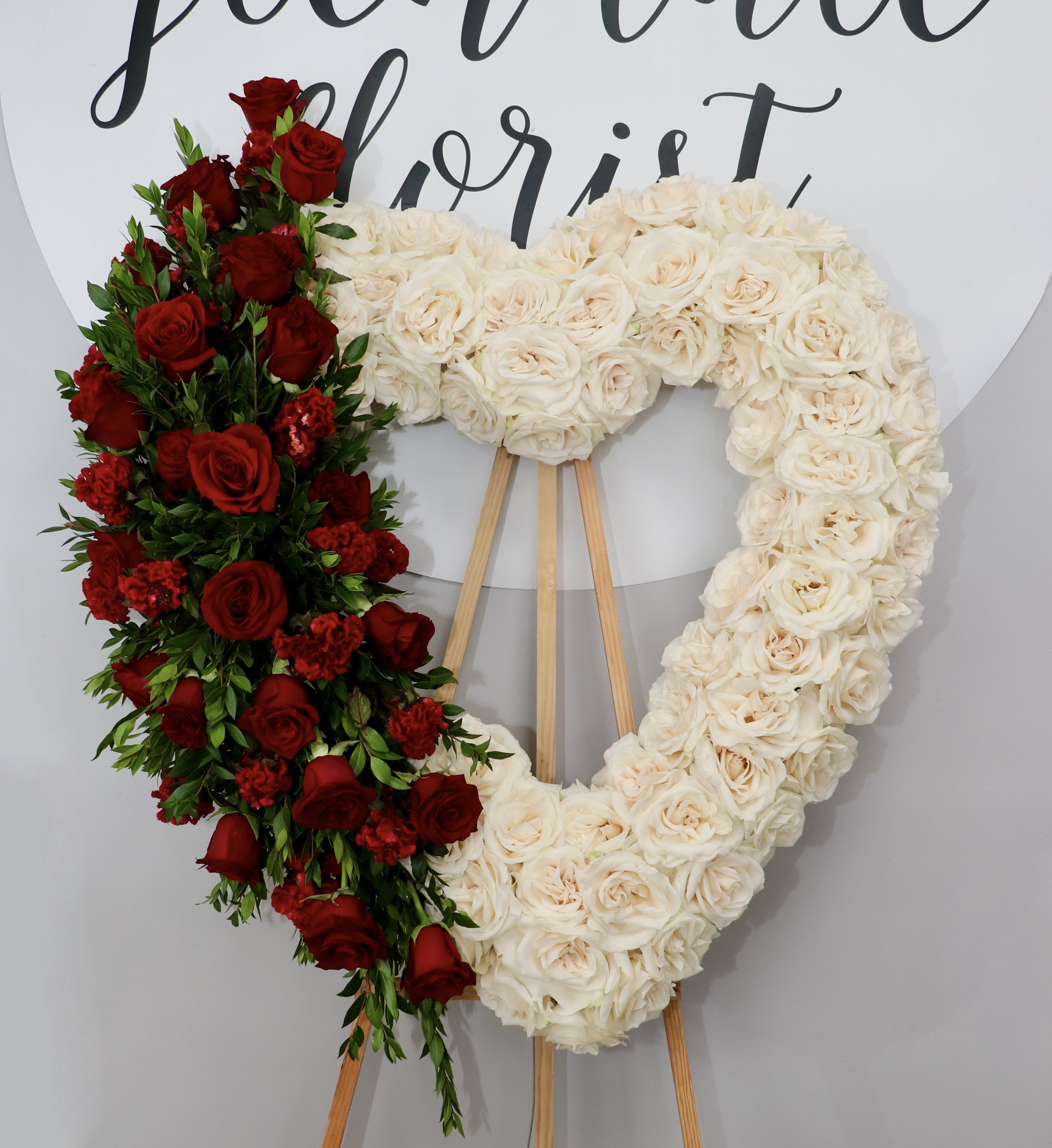 Forever Love Heart  - This sympathy heart is made with all white roses and accented with a red rose design.  We include easel, printed banner and delivery (some fees may apply). An additional banner can be added for $15  Standard size is 30'', deluxe is 36'', and premium is 42''.