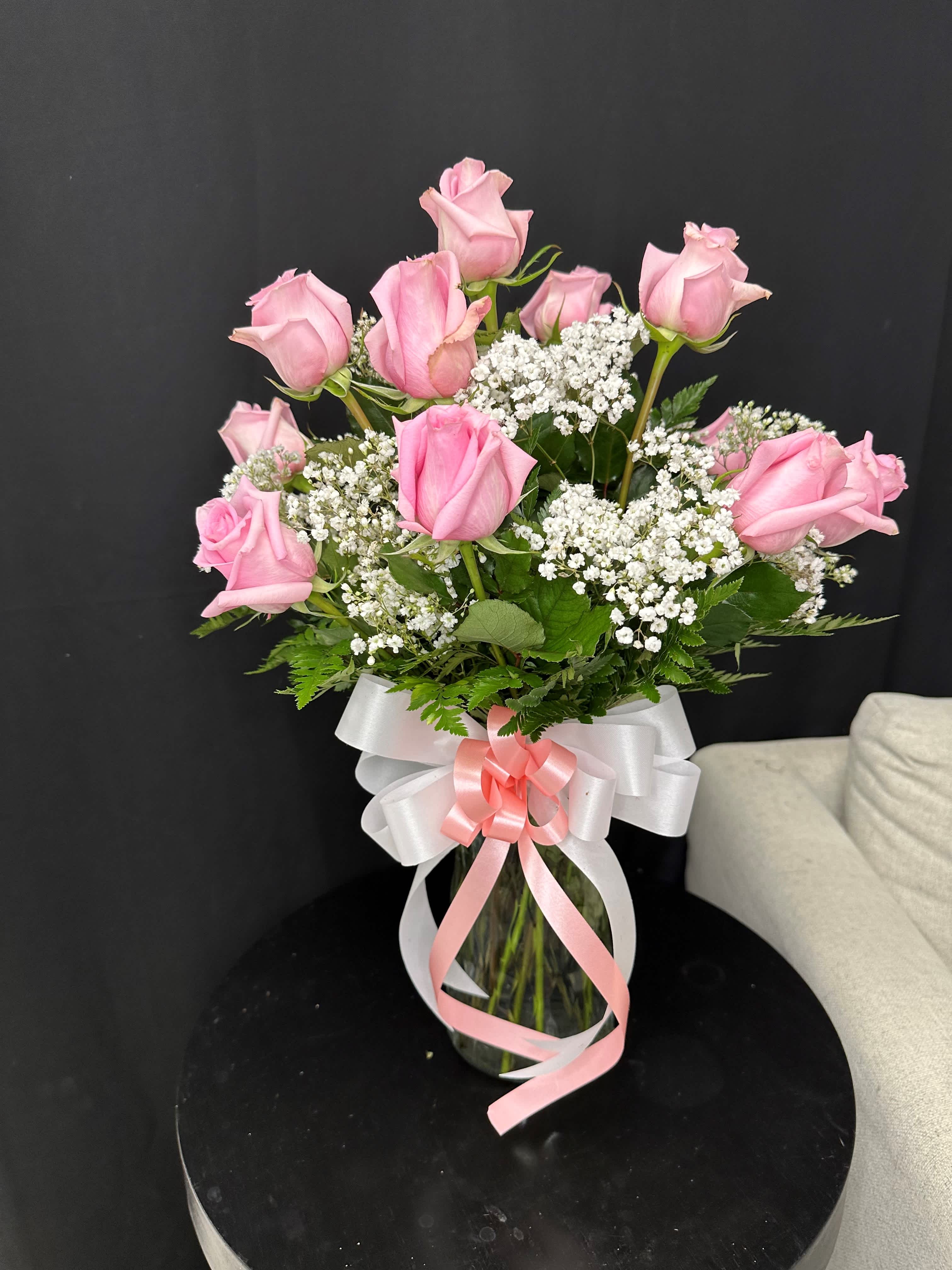 Dozen Long Stemmed Pink Roses -  Elevate any occasion with the timeless elegance of a dozen exquisite pink roses. Each bloom whispers of grace and affection, making it the perfect gesture to convey love, admiration, or appreciation. Let these delicate blossoms enchant the senses and leave a lasting impression of beauty and romance.