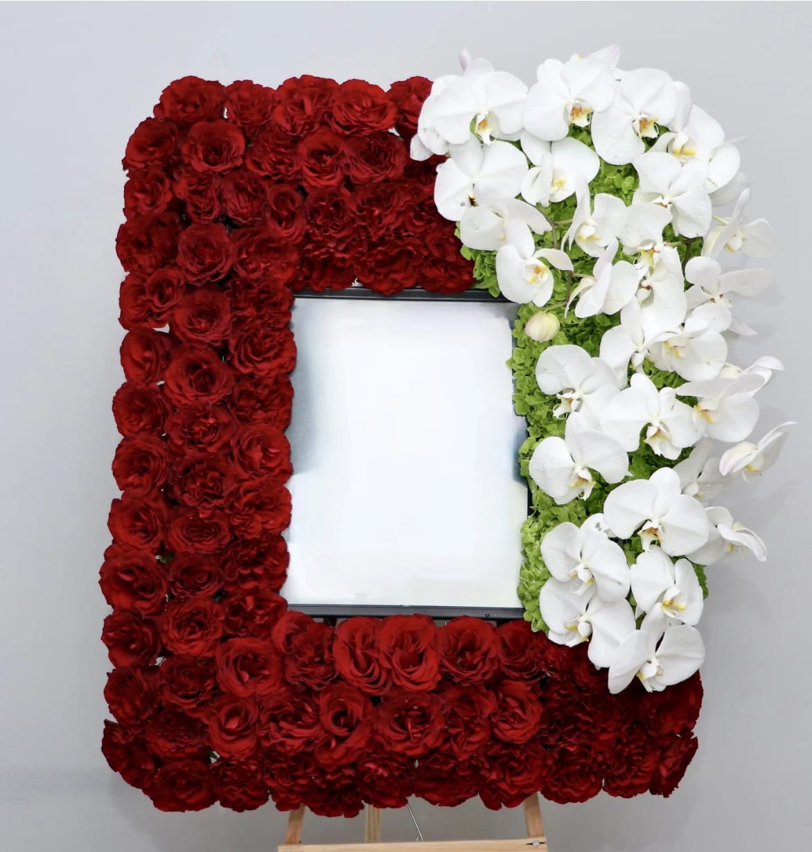 Orchid &amp; Red Rose Frame  - This elegant frame is made with red roses and a corner accent of delicate white orchids in a bed of green hydrangea.    It stands at approximately 32 inches tall in the standard size. Frame is not included. Coordinate with use for drop off and allow 2-3 days. 11''x14'' frame is best.    We include easel, printed banner, and delivery (some fees may apply). An additional banner can be added for $15.    