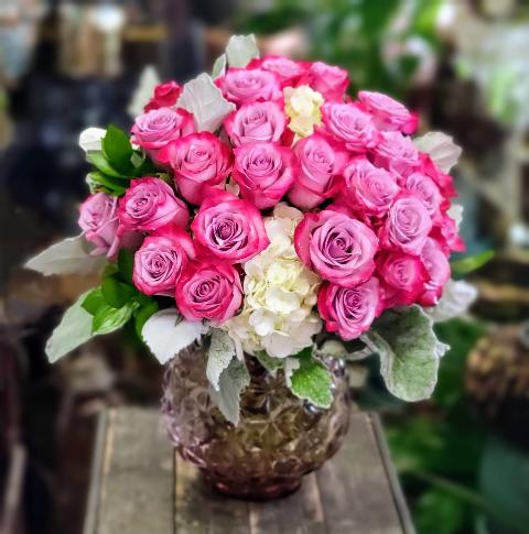 Natalia - 25 Lavender roses, hydrangeas, and greenery arranged in amethyst glass vase.