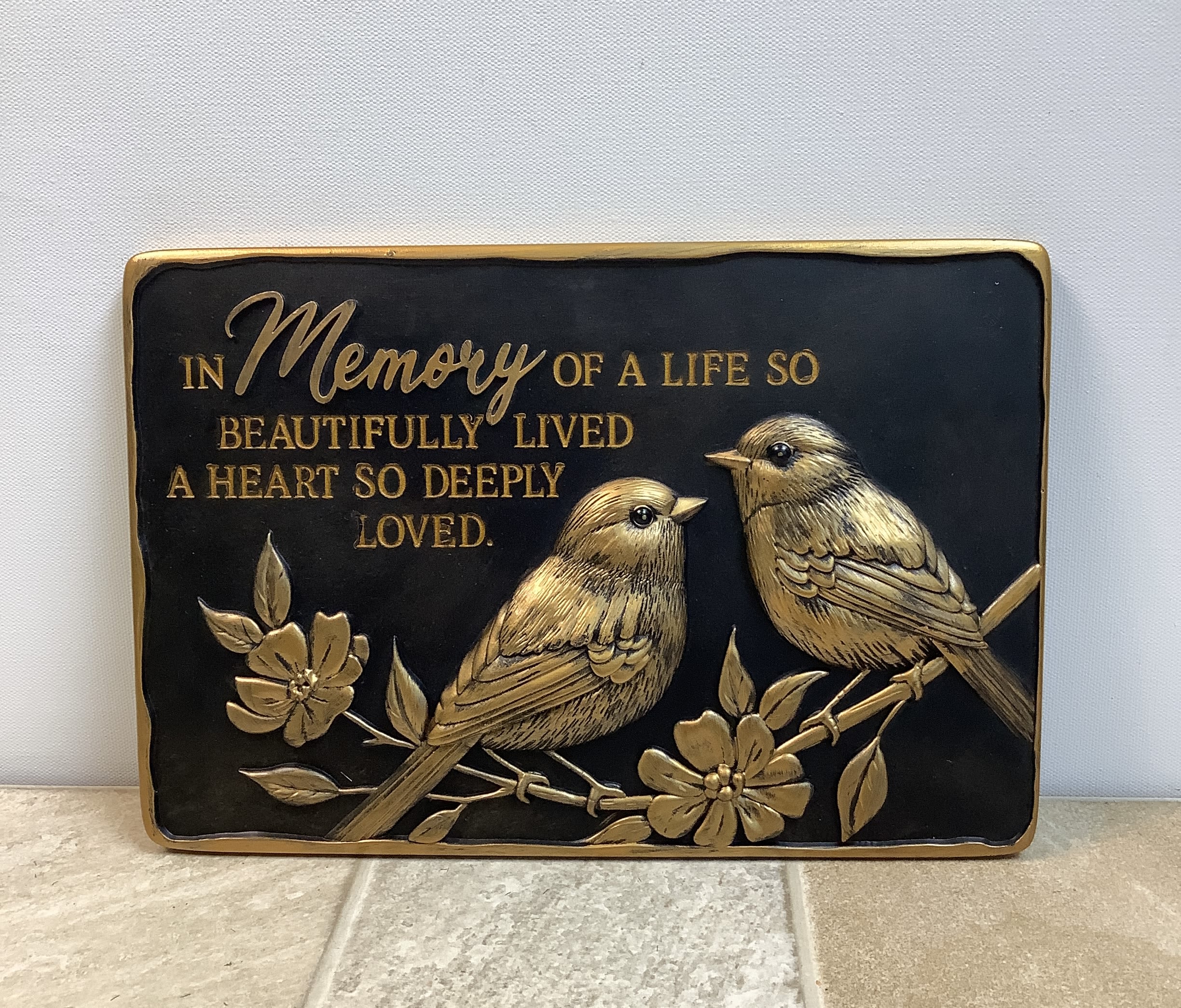 Stepping Stone - Gold Birds - This keepsake rectangular decorative plaque is perfect as a memorial or garden stone. It has a black background with gold-colored accents and two birds with the saying "In memory of a life so beautifully lived. A heart so deeply loved." 12" wide x 8" high.