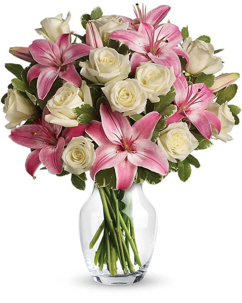 Always a Lady - A romantic gift like this one is always appreciated. An eye-catching display of roses and lilies is perfectly arranged in a feminine vase which makes a beautiful and lasting impression. Elegant white roses and sweet pink asiatic lilies are hand-arranged with greens. It's the perfect way to show you love her always and forever.