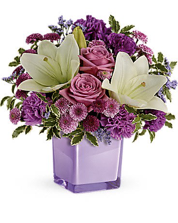 Pleasing Purple Bouquet - These luxurious lavender roses and crisp white lilies are poised to please! Perfectly presented in a stylish cube vase, it's an any-occasion surprise they'll never forget!  Lavender roses, white asiatic lilies, purple carnations, lavender carnations, purple button spray chrysanthemums and lavender button spray chrysanthemums are arranged with lavender limonium and pitta negra. Delivered in a glass cube.  Approximately 13 1/2" W x 13 3/4" H  Orientation: One-Sided
