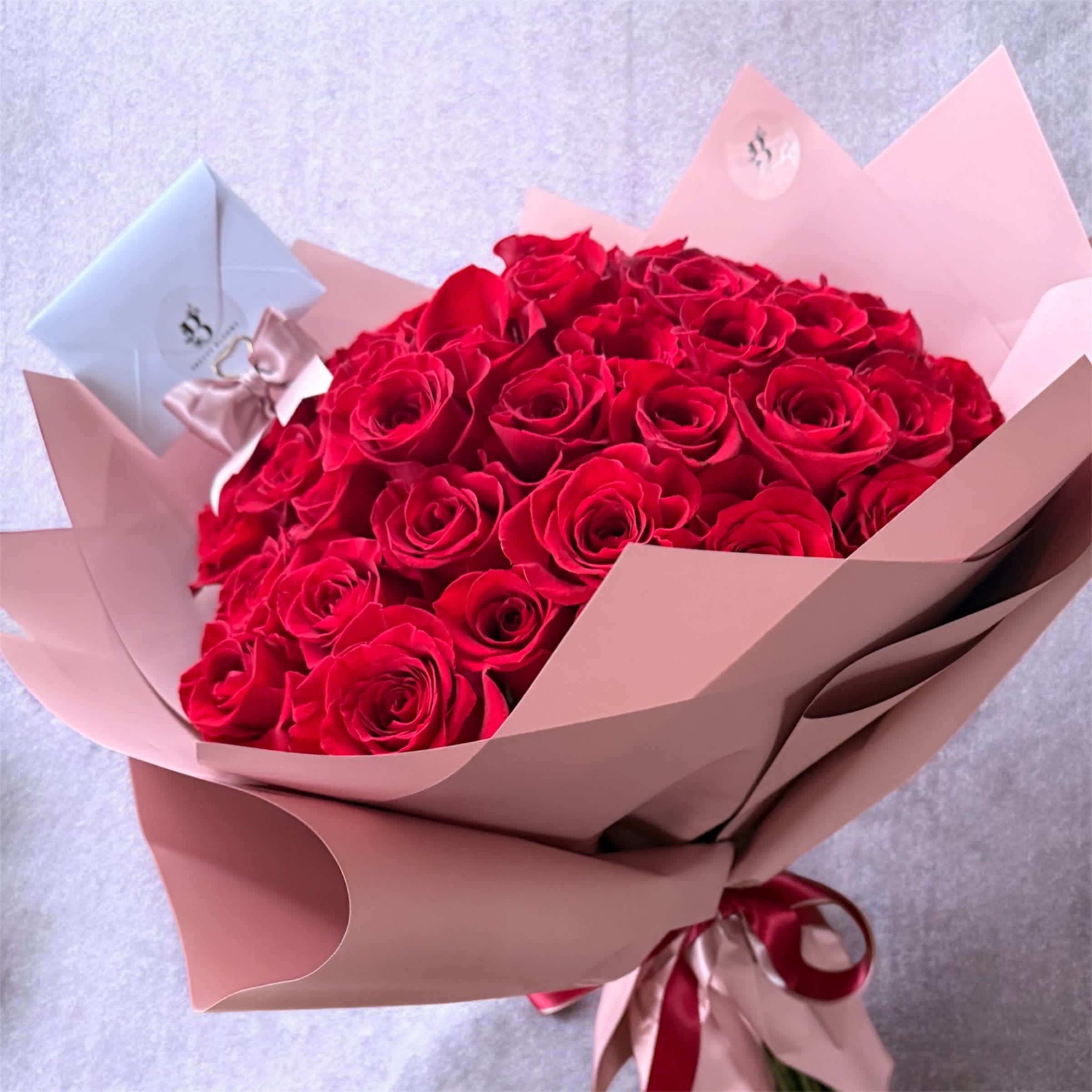 Red Roses Bouquet - A Stunning wrapped bouquet of 50 long stem premium red roses. Perfect for expressing love, romance and affection.  Choose your wrapping paper, white, red or pink.