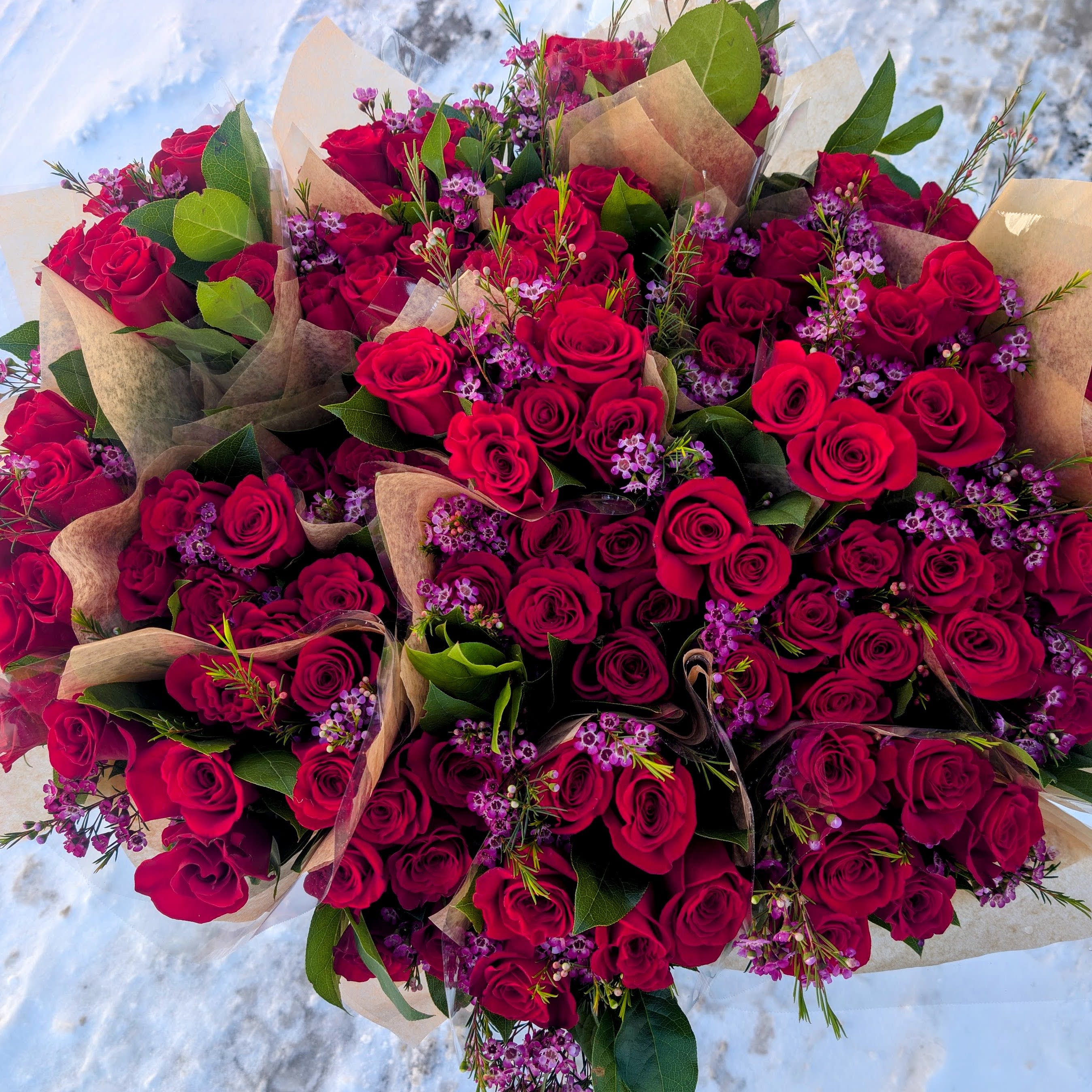 Dozen Red Roses Wrapped - One dozen hand tied red roses with greens and accent fillers.   Only available for pick up 