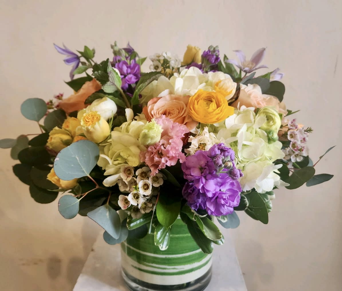 Rainbow Sherbet - A collection of bright blooms in a fun range of colors, designed in a sleek, ribbon leaf-wrapped cylinder. 