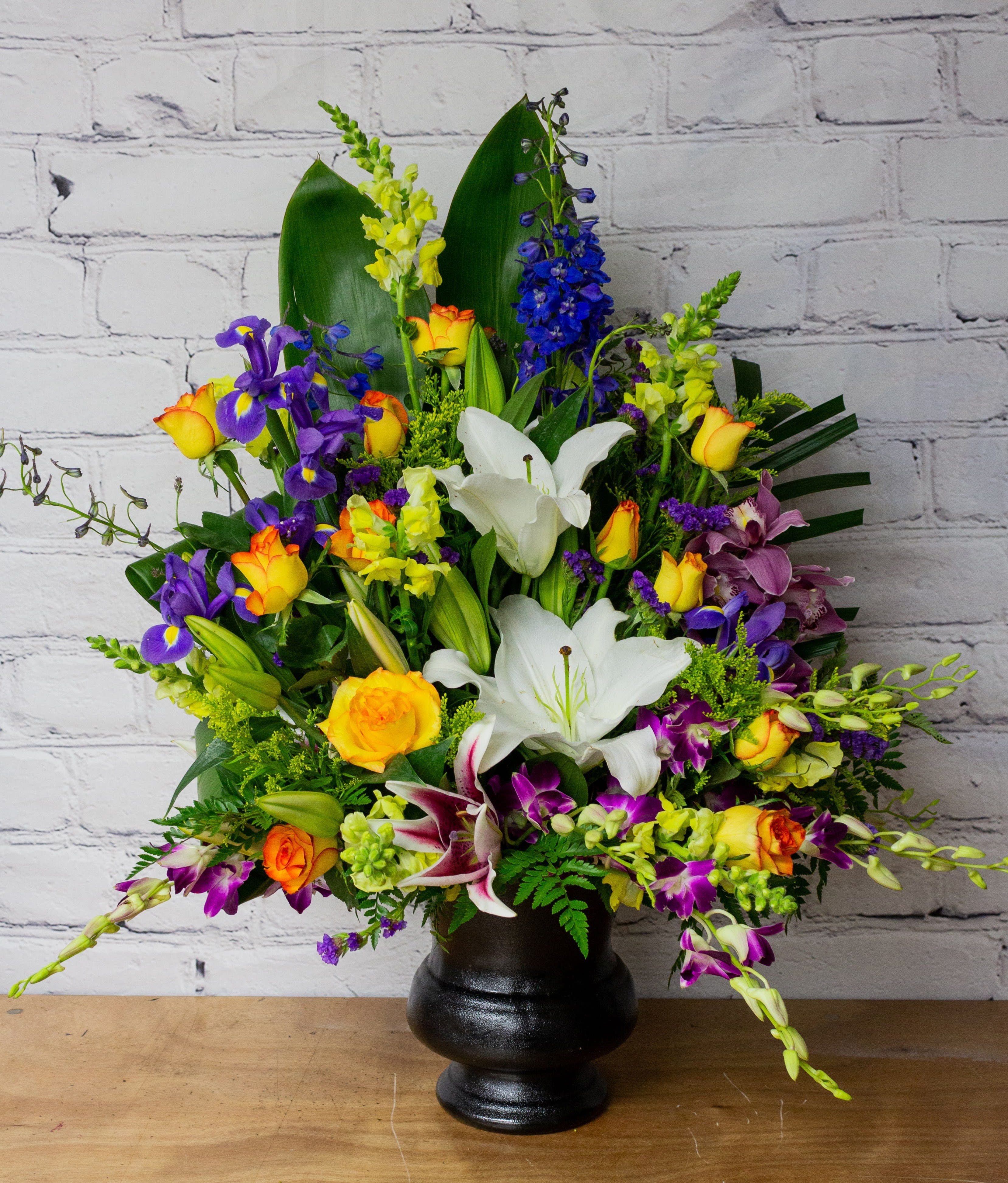 FUNERAL FLOOR SPRAY - Joyful Memories 104 - This funeral/sympathy arrangement is a wonderful choice to memorialize your loved one with a cheery, tropical arrangement. It comes with a variety of yellow, purple, and blue blooms including lilies, orchids, roses, irises, and delphinium. Standard as shown in first photo; please indicate any specific color variations in your order.   **This is a piece for a funeral or memorial service. Please place the order at least 2 days prior to the service to guarantee a certain arrangement. Anything sooner and we cannot guarantee it will match the picture. These pieces can be customized to the color of your choice. The flowers may vary depending on availability of the flowers, special requests and quality of the flowers we have in stock. If you have a special request please add it to our special instructions when placing your order. If you have any questions please don’t hesitate to call. 714 289 1123**