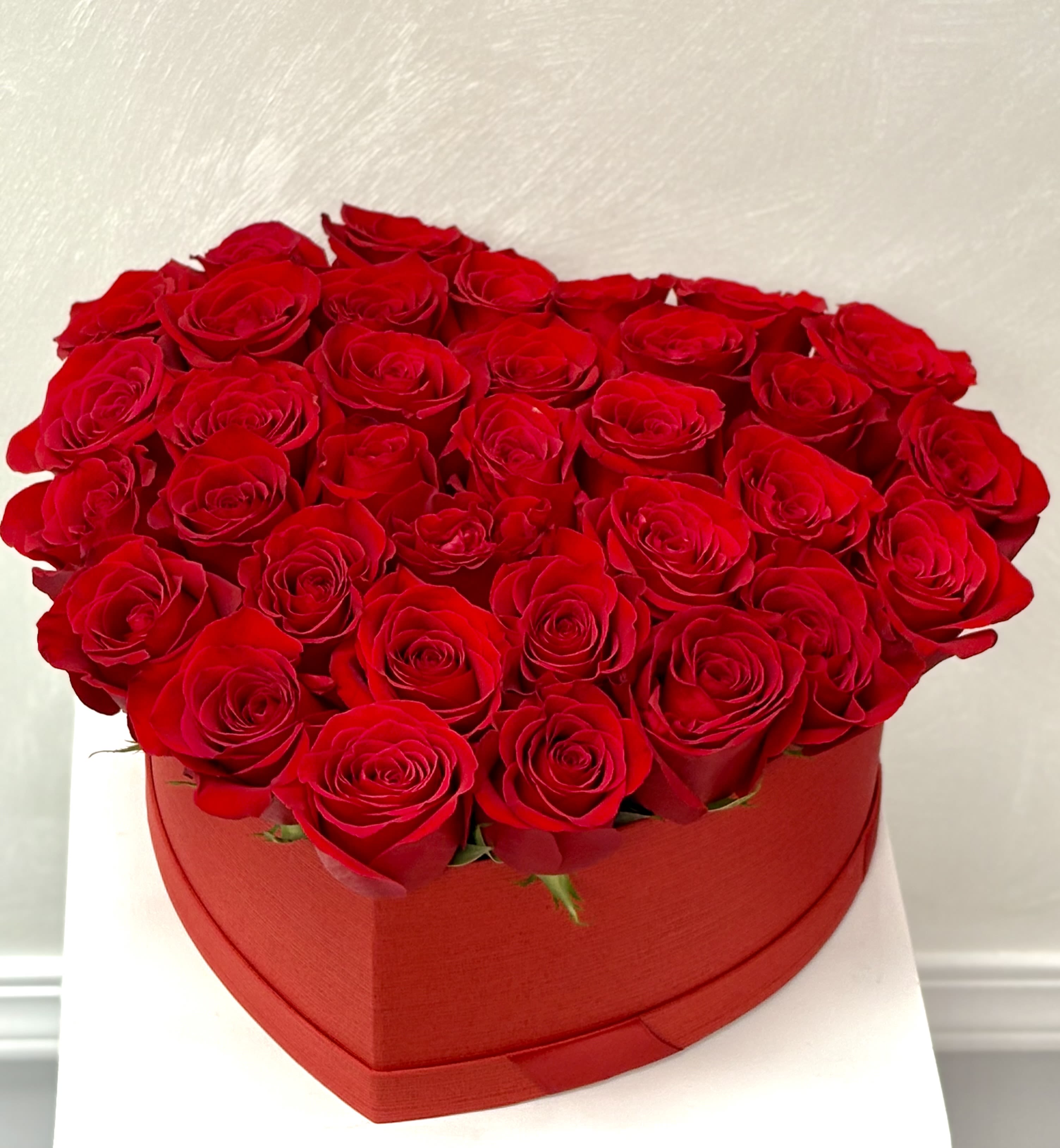 Forever Yours By VLM Flowers - A romantic masterpiece of velvety red roses crafted into a perfect heart. Presented in a stylish red box, this arrangement embodies passion, commitment, and timeless love.